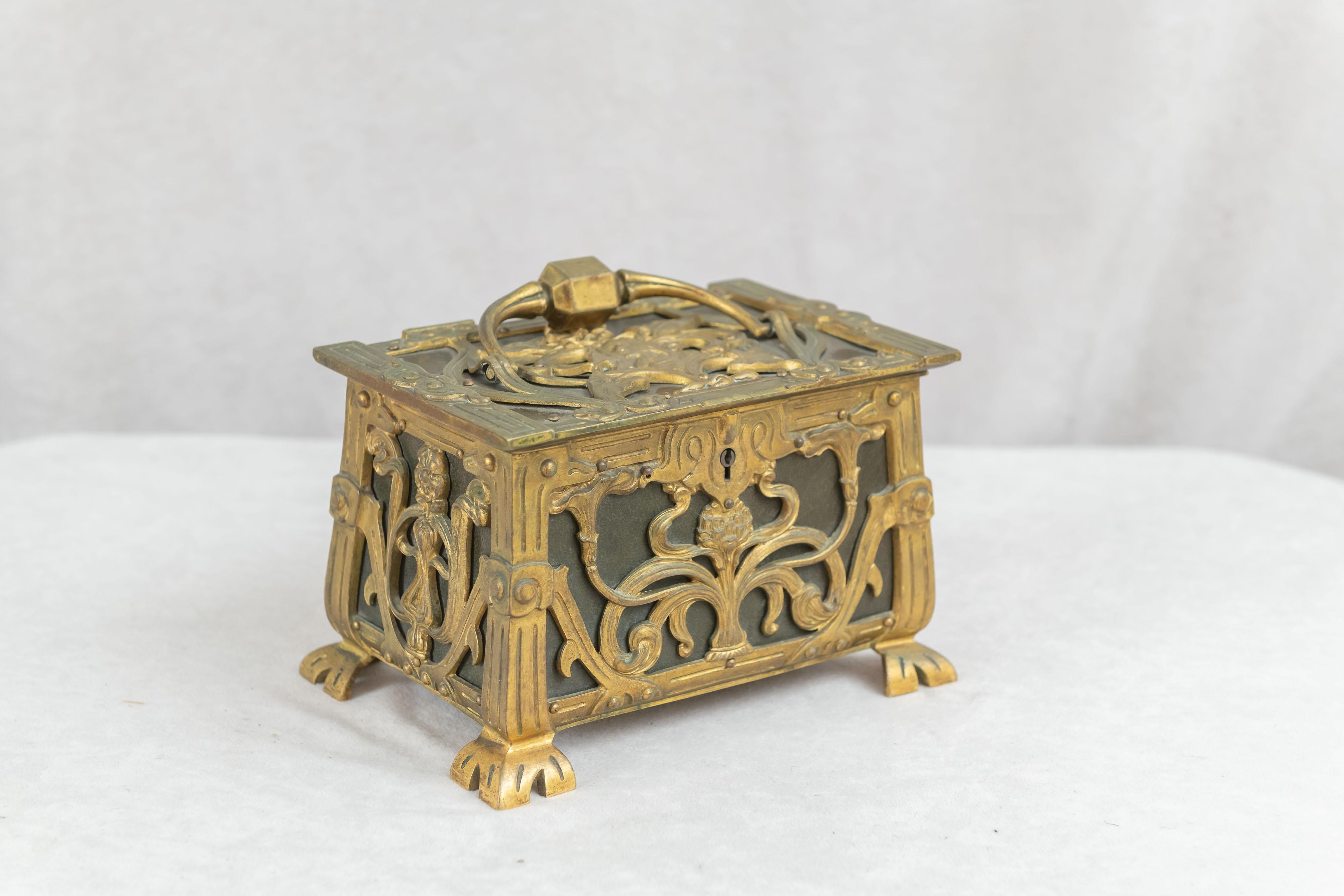 This luscious jewelry box is about as art nouveau as it can be. Sinewy lines all around and a cameo of a woman on the top. The original interior is lined with velvet. The box is quite substantial, and capped off with that big handle on the top. A