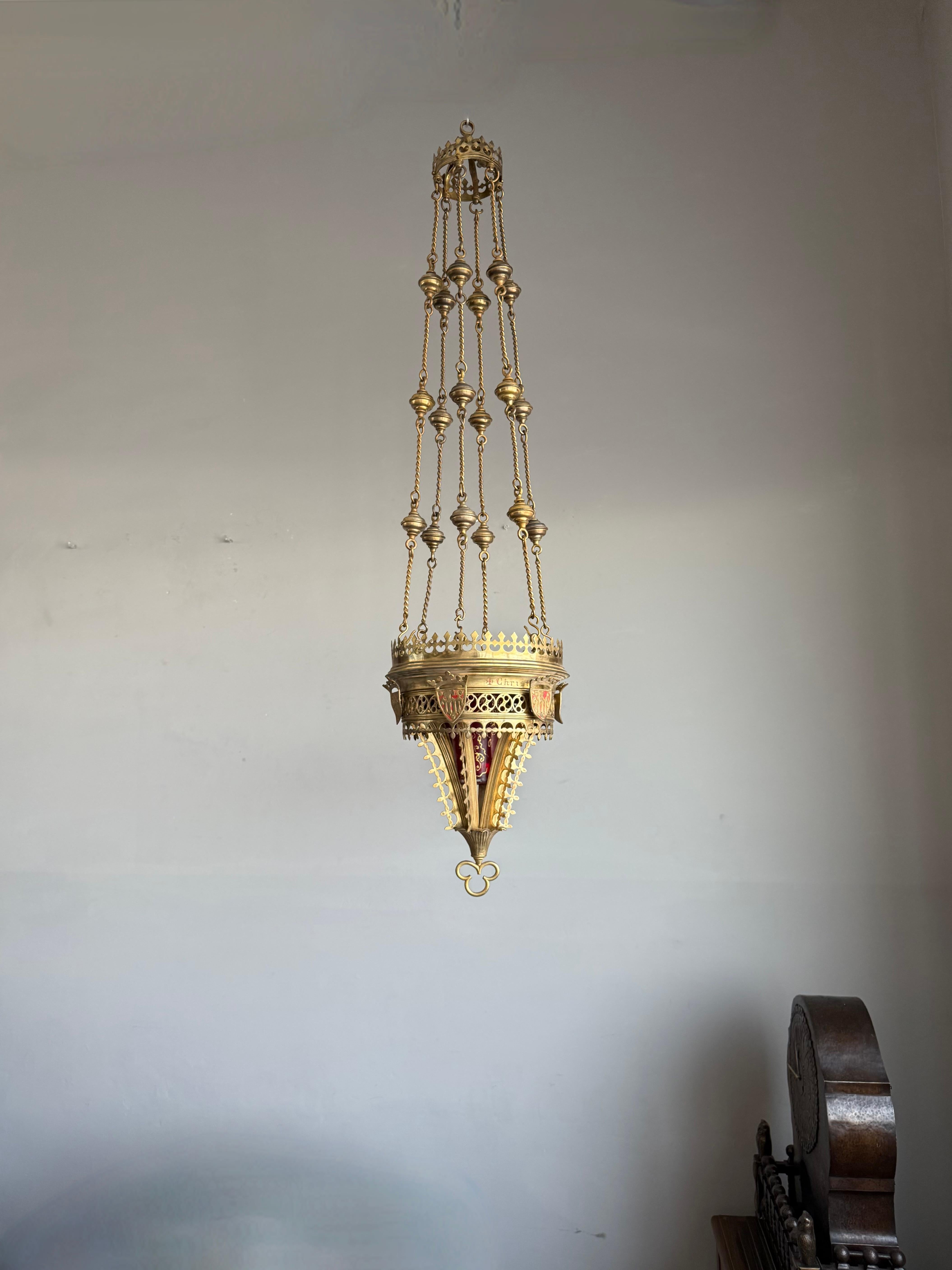 Stunning 19th century Gothic art pendant with shields and gilt scrolling patterns.

This late 1800s church relic truly has an aura of religiousness about it. This sanctuary pendant is entirely handcrafted and for the most part in solid bronze with a