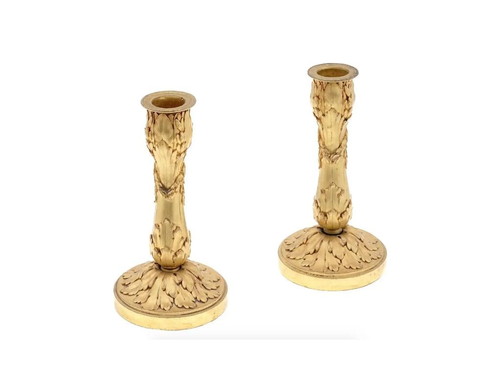 A pair of antique late 19th to early 20th century French gilt bronze candlesticks with vegetal design. Embossed marks Susse Freres, C. Lelievre Fils on the base of both pieces. Susse Freres was a French bronze foundry and daguerrotype camera