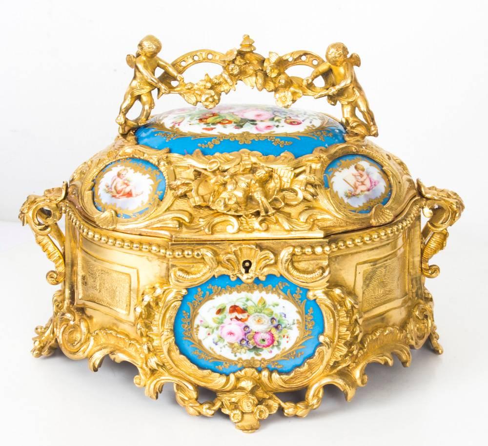 This is a fine antique French 19th century gilt bronze casket set with beautiful hand-painted Sevres porcelain panels.
 
The casket features inset hand-painted Sevres porcelain panels depicting summer flowers and cherubs on a bleu celeste ground