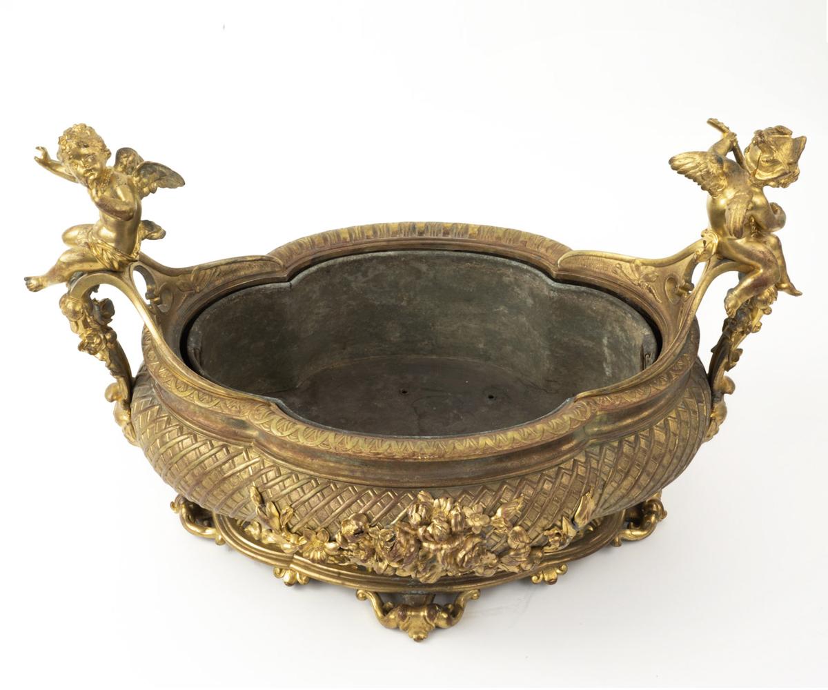 This gilt bronze centerpiece is late 19th century and features two angels on perched n the handles and multiple levels of intricacy both on the bowl and base. The workmanship is superior as can be ascertained in the quality of the figures and