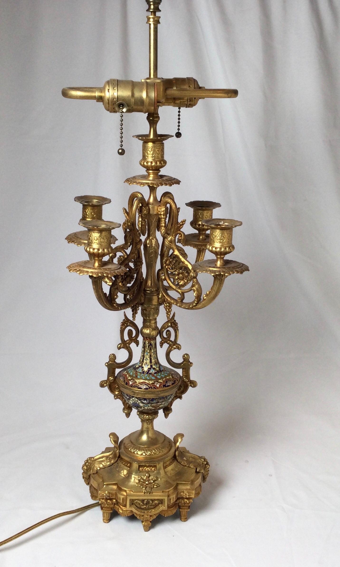 Elegant gilt cast bronze 19th century candelabra with four arms and center arm. The bronze with champlevé enamel decoration. The shade is for photographic purposes only and not included. New Wiring. The lamp with a shade is 29.5 inches high.