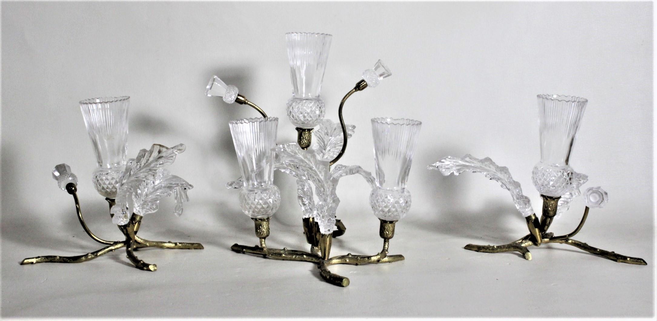 This three-piece antique gilt bronze and cut crystal convertible bud vase centerpiece set is unsigned, but presumed to have been made in Ireland in circa 1920 in an Art Nouveau style. The set is composed of three cast and gilt bronze figural sprigs