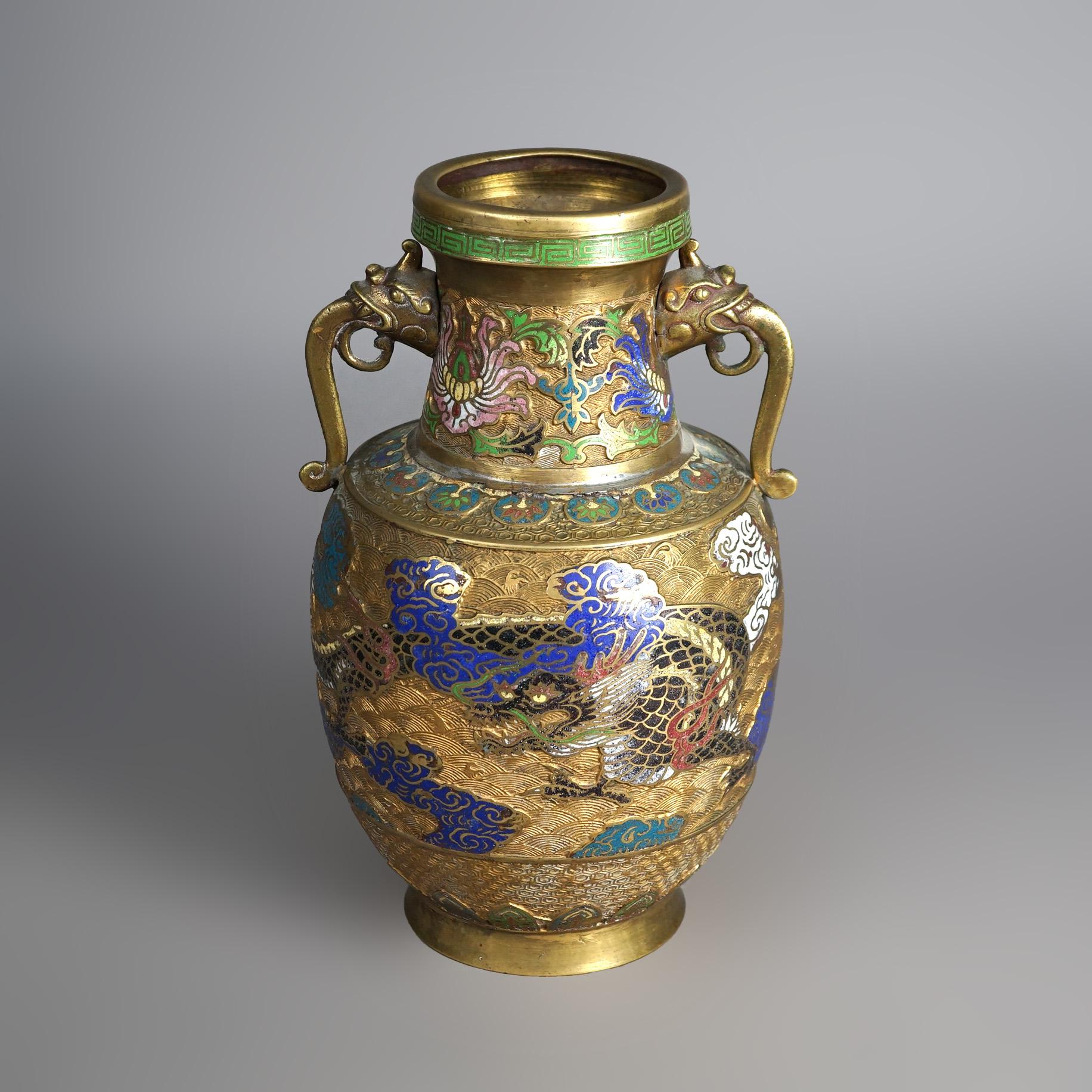 An antique Japanese figural vase offers gilt bronze construction with double figural handles and cloisonne enameled decoration including dragon, clouds and foliate elements; stamped on base as photographed; c1920

Measures- 14.25''H x 8.25''W x