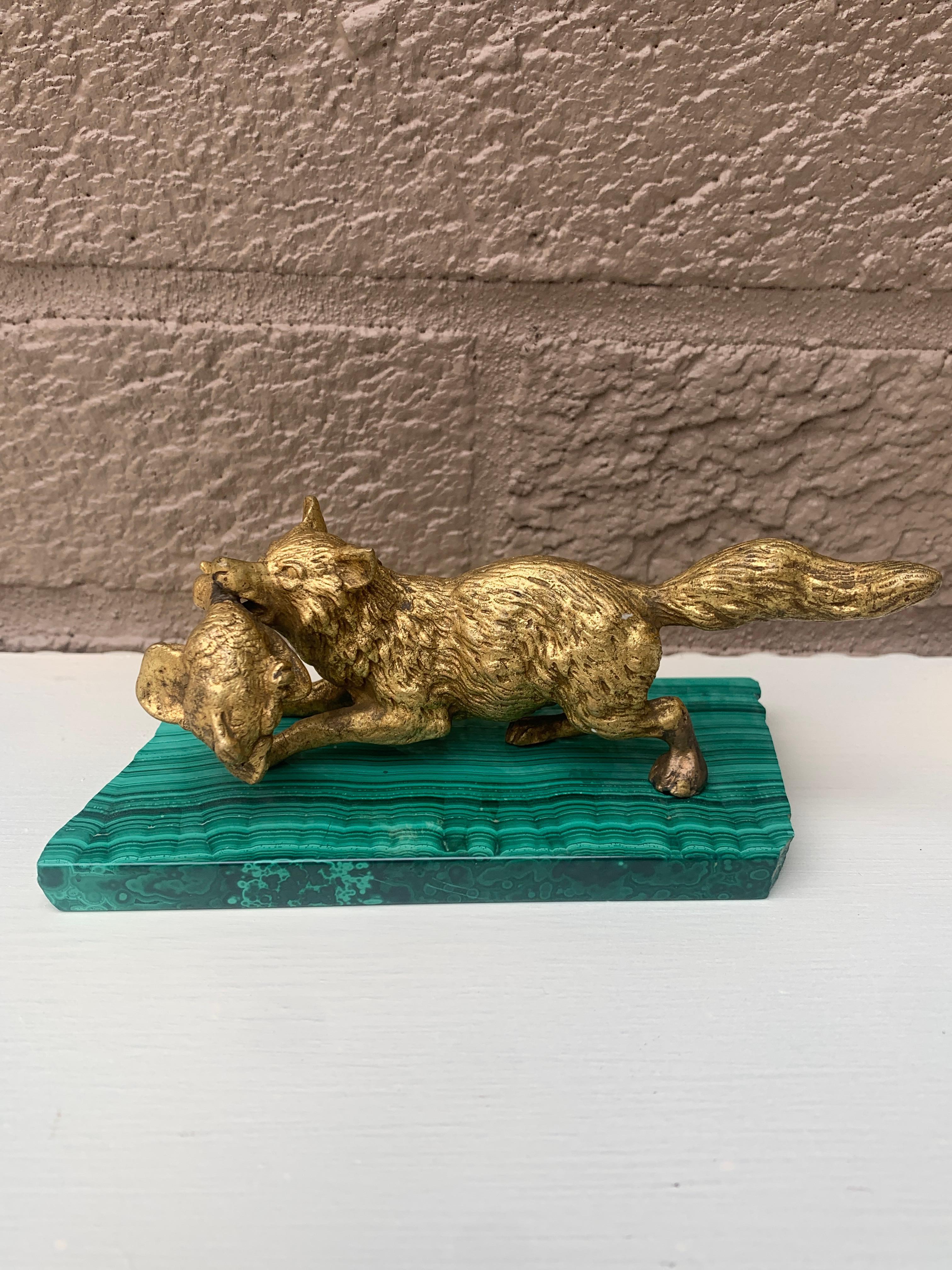 Preciosa escultura antigua de bronce dorado de un zorro cazador con un pato en la boca, montada sobre una losa de malaquita pulida

Europea (probablemente alemana o rusa), Principios del siglo XX

Medidas: 5