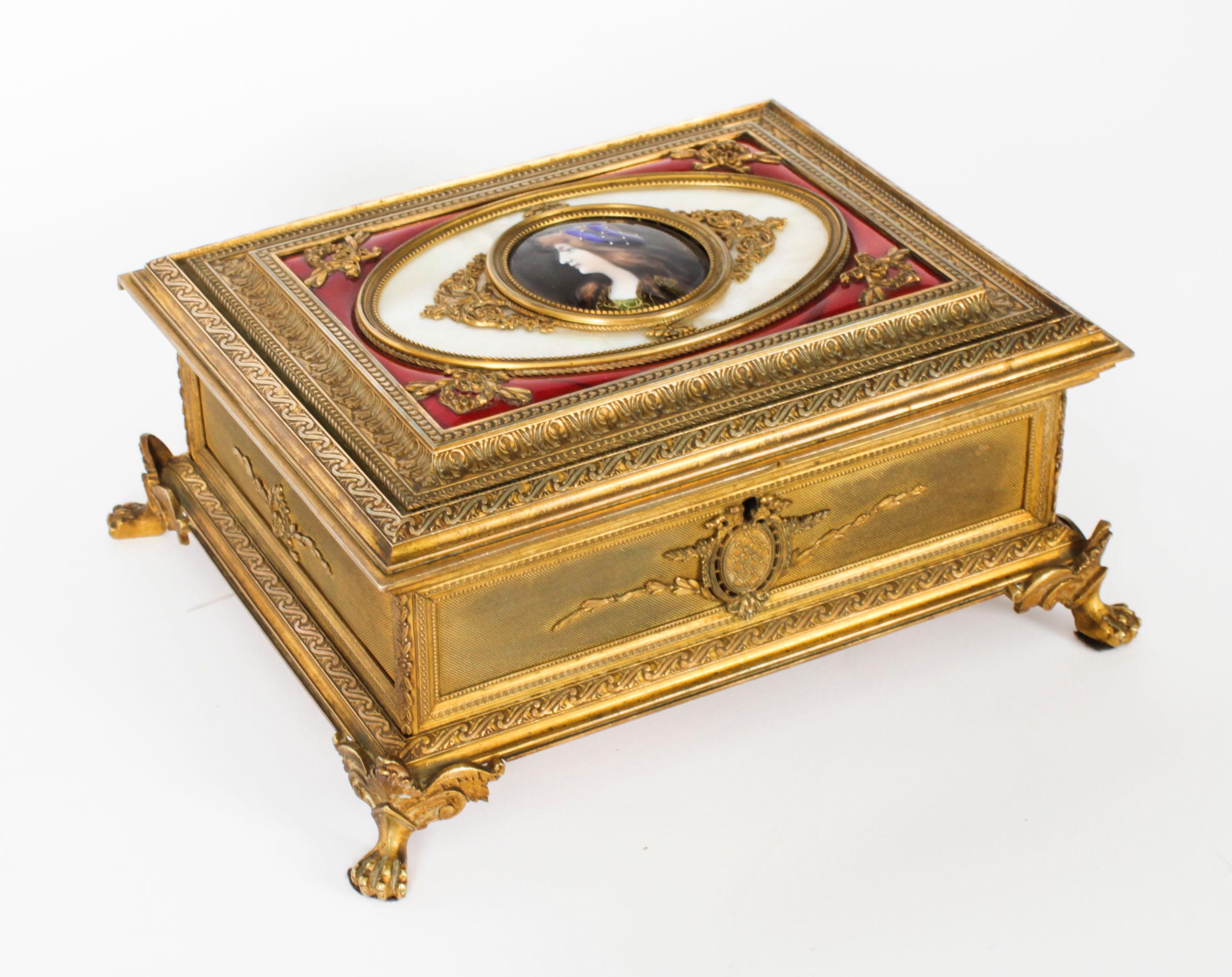 This is a beautiful antique Napoleon III gilded ormolu and Limoges enamel jewellery casket, Circa 1870 in date.

The hinged lid having a beautiful finely painted miniature Limoges enamel portrait bust of a young lady, signed L.C., on an oval panel