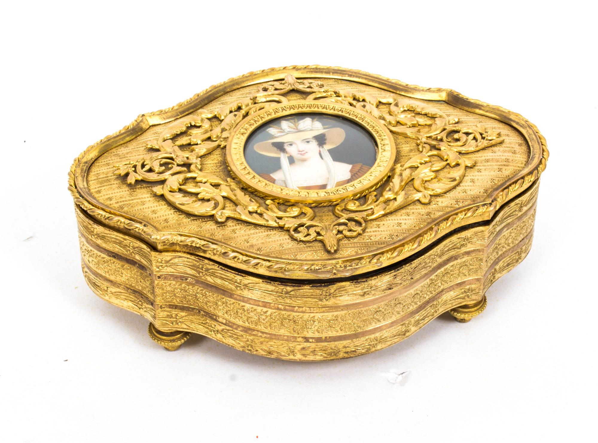 This is a beautiful antique gilded ormolu serpentine shaped jewellery casket, Circa 1870 in date.

The top, front, sides and back are beautifully cast and tooled in gilt bronze. The rope outline frames delicate leaf work borders, the filigree