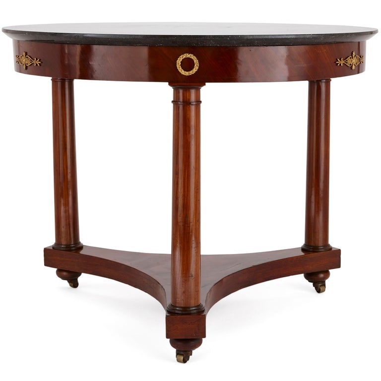 This elegant table was created in France during the Bourbon restoration, following the fall of Napoleon I in 1814. The table is designed in a refined Neoclassical style, which was popular in this period.

The table features a circular black fossil