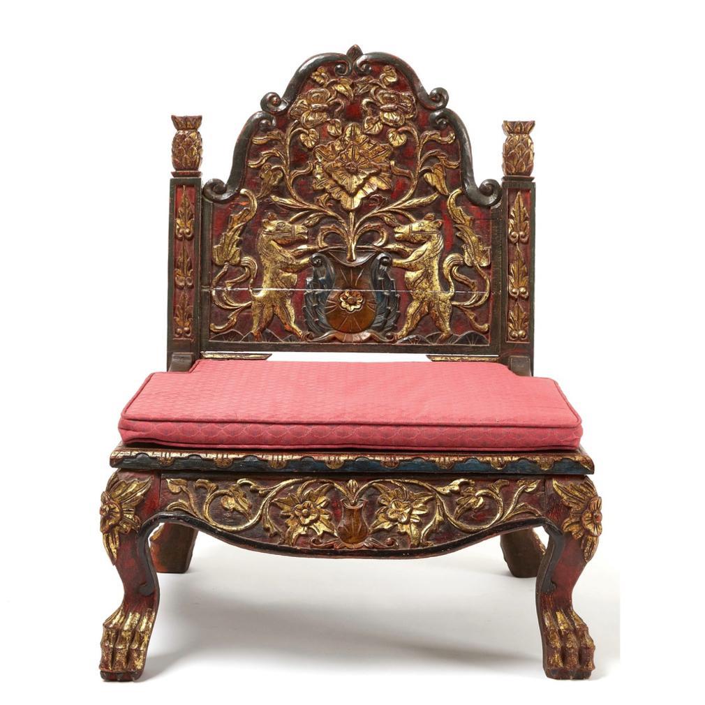 Antique Gilt-Carved Red and Black Lacquer Javanese Ceremonial Circumcision Chair. A low teak chair carved having cabriole legs, claw feet, skirt detail in a tendril floral relief, solid seat, back uprights with recessed leaf carving and lotus