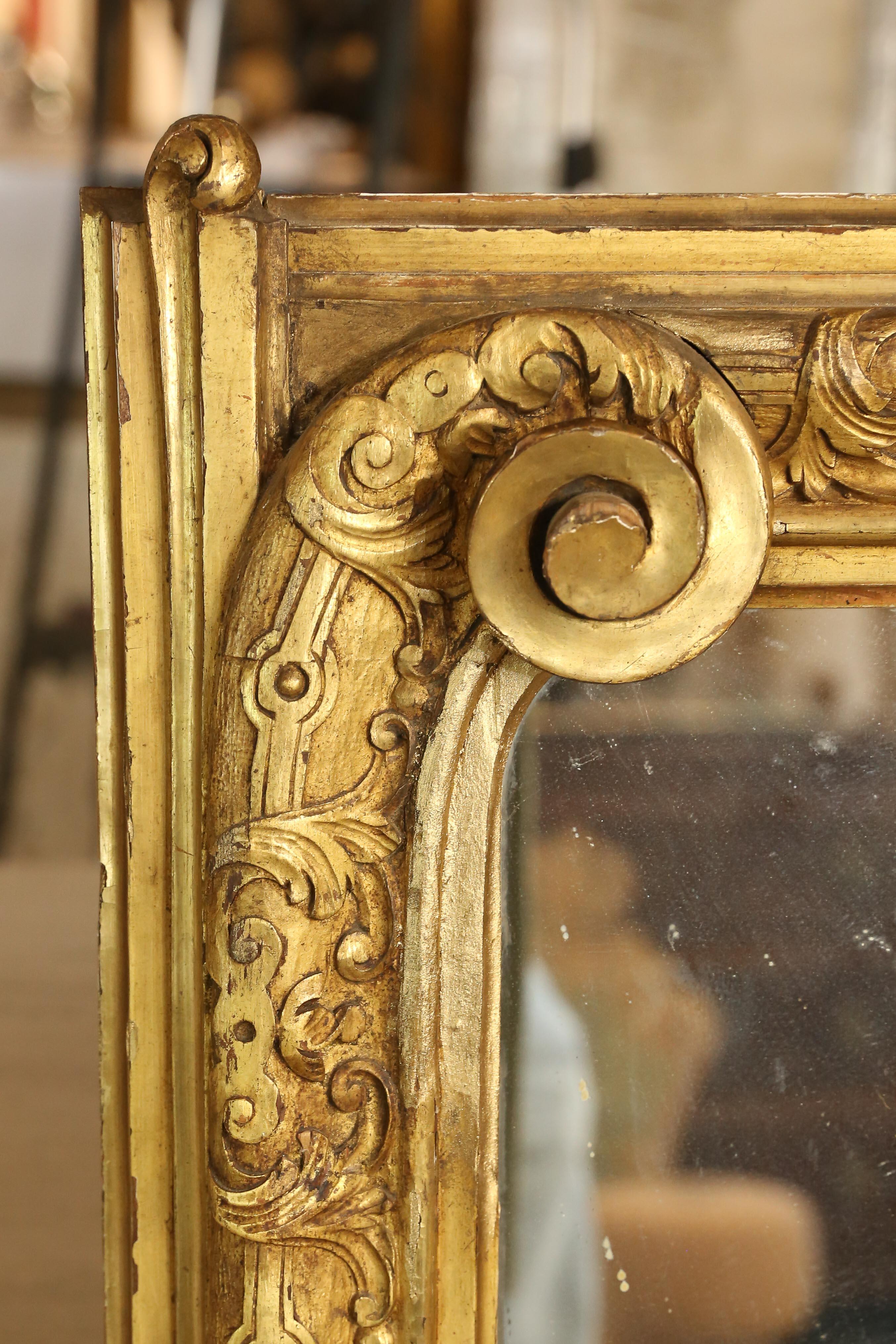 This is a fantastic antique French carved mirror, the scroll details at the upper corners are simply stunning. The entire frame is carved, with repeating scroll and leaf details. Another gorgeous detail of this mirror is the extension of one of the