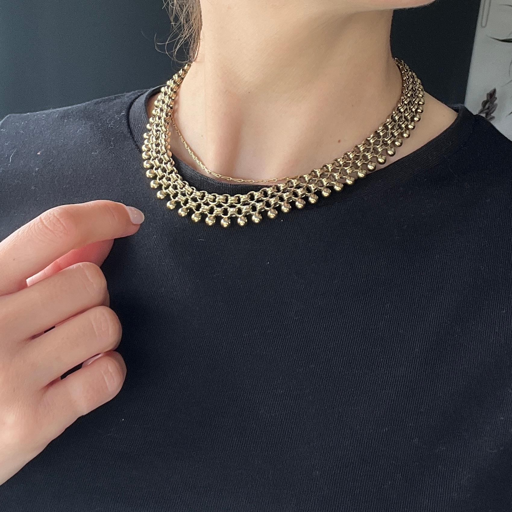 This beautiful gilt collar is flat and sits beautifully. The smooth hoops are linked with decorative links and the necklace is fastened with a large bolt clasp. 

Length: 41cm
Chain Width: 14mm 

Weight: 39g