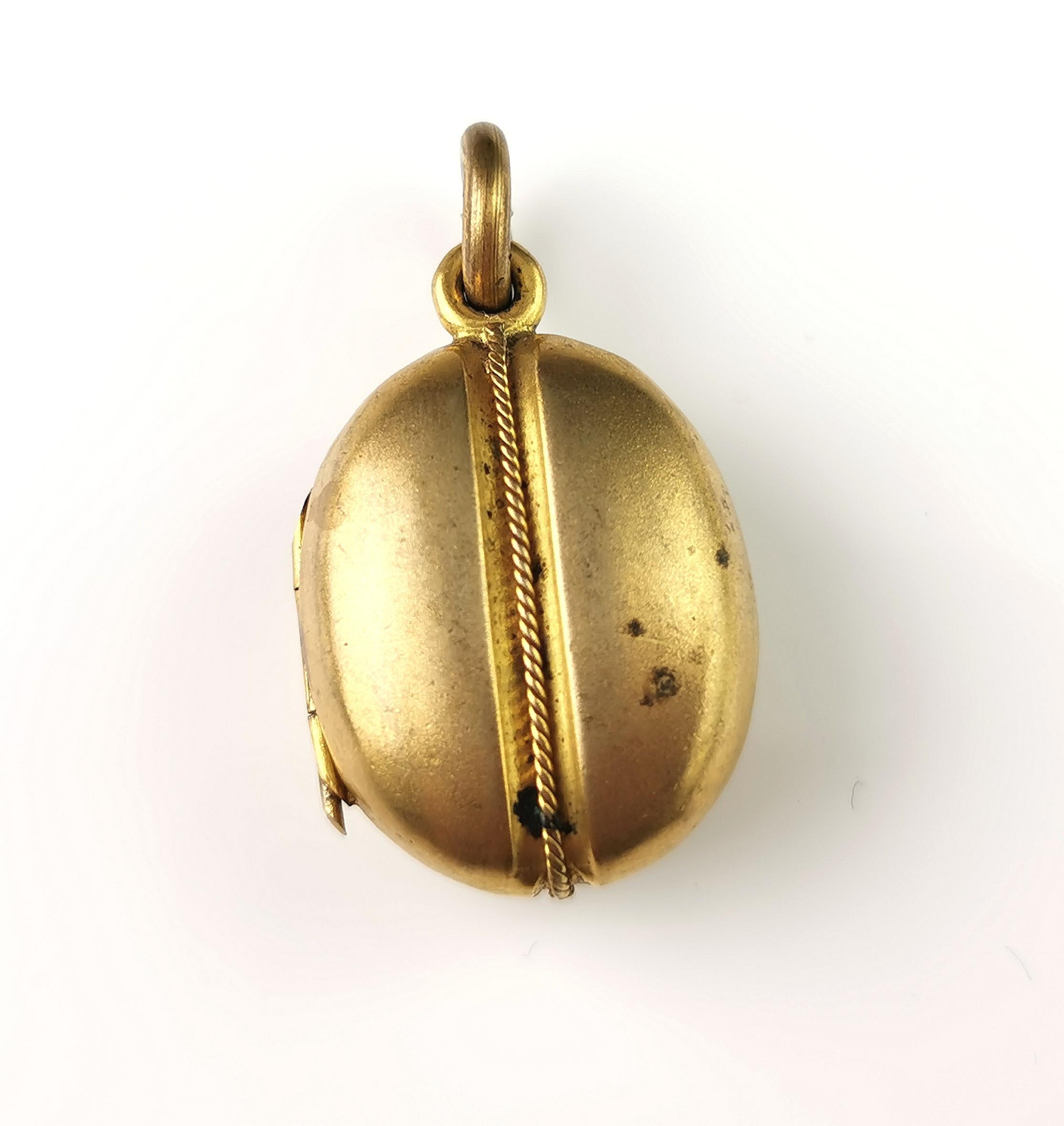 A charming antique Edwardian era gilt metal coffee bean locket.

This locket is a chunky little locket, some wear front and back but still lots of life left to give, it holds two pictures or tiny mementos, one side has a replacement glazing and one