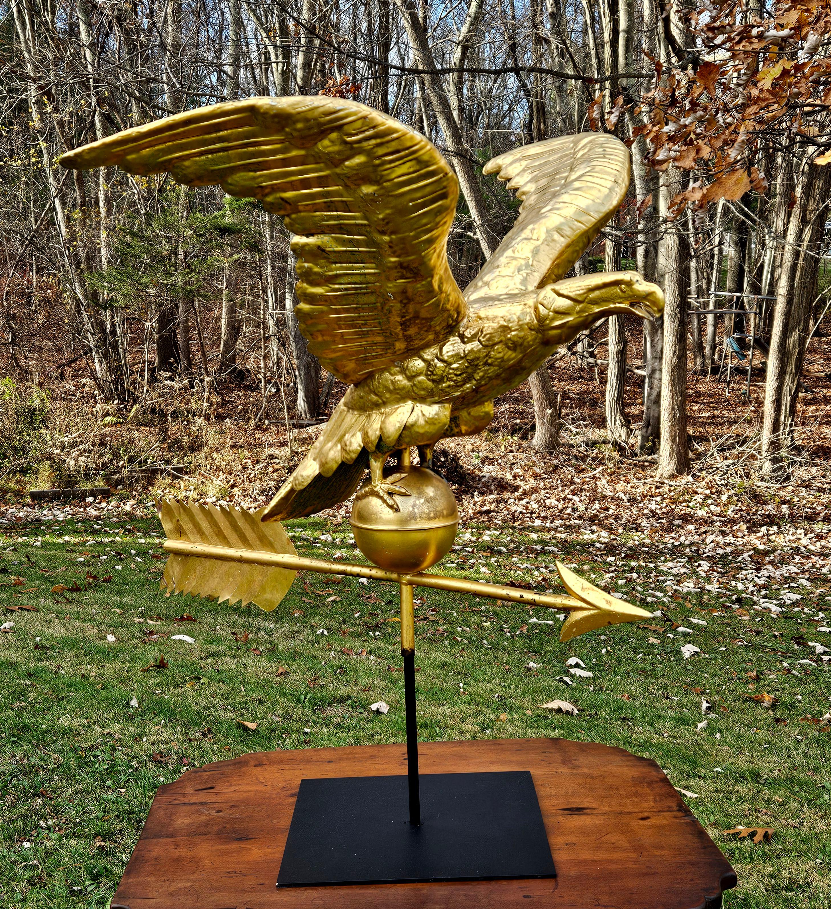 Veleta de águila real de cobre dorado del siglo XIX. Un águila posada sobre una bola y una flecha en un soporte de metal resistente.

Dimensión del águila: Envergadura: 31
                              Longitud de la flecha: 30
                     