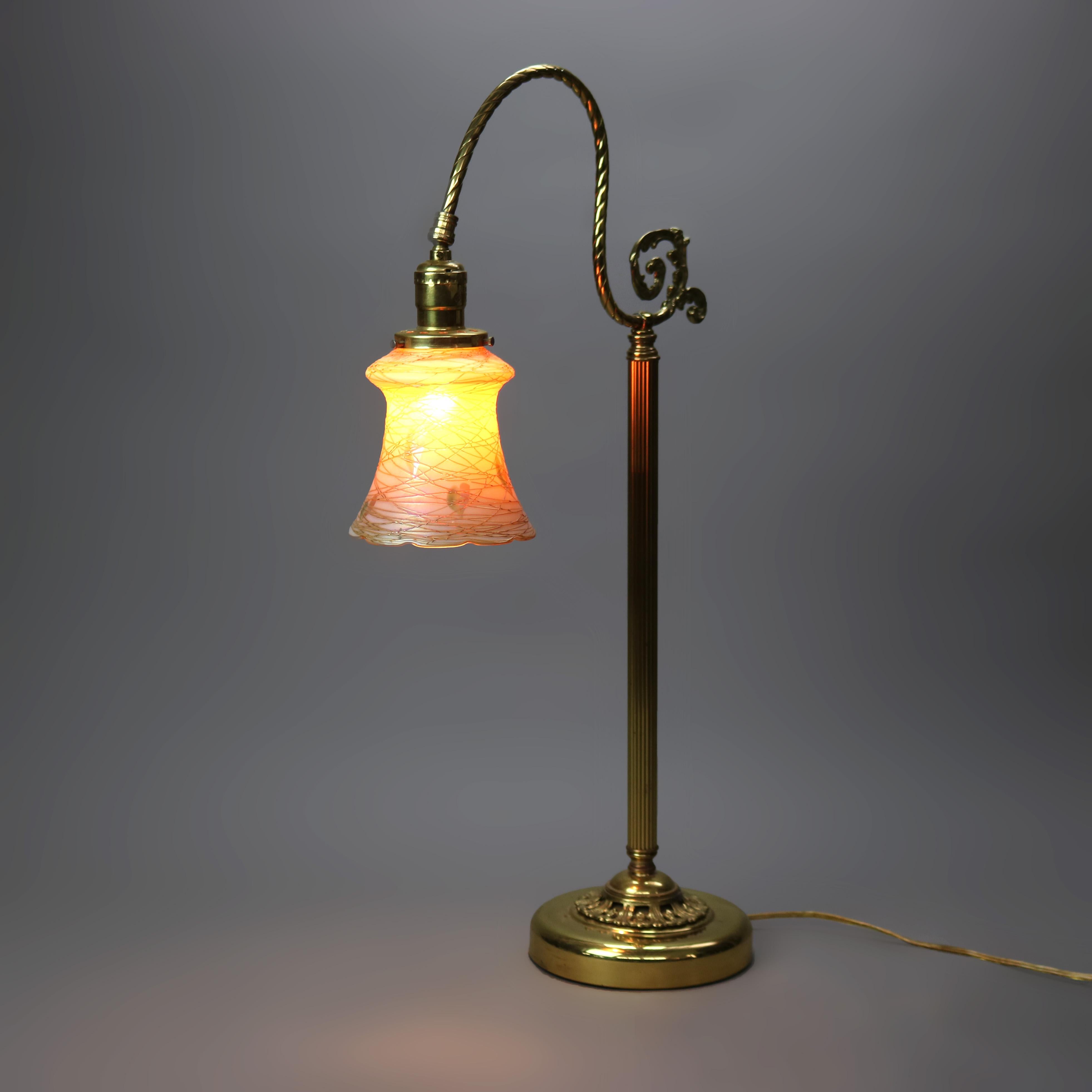 An antique desk lamp offers gilt cast metal base with goose neck terminating in Quezal art glass shade, c1930

Measures- 26''H x 6.75''W x 14''D.