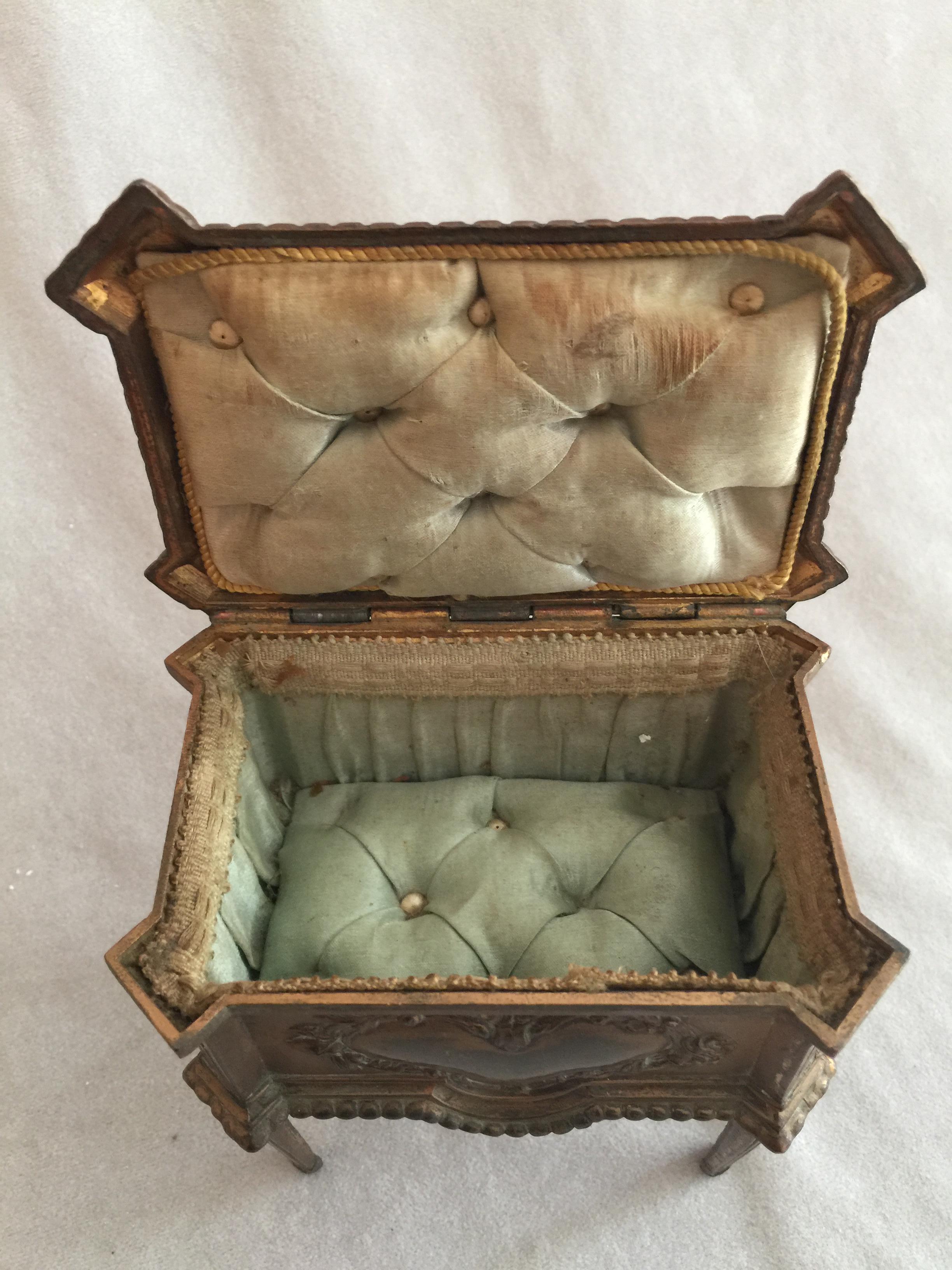 This rather unusual jewelry box is in the form of a cabinet with 4 legs. It does retain it's original tufted lining, a nice bonus on any antique jewelry box. 
 It bears the French marking 