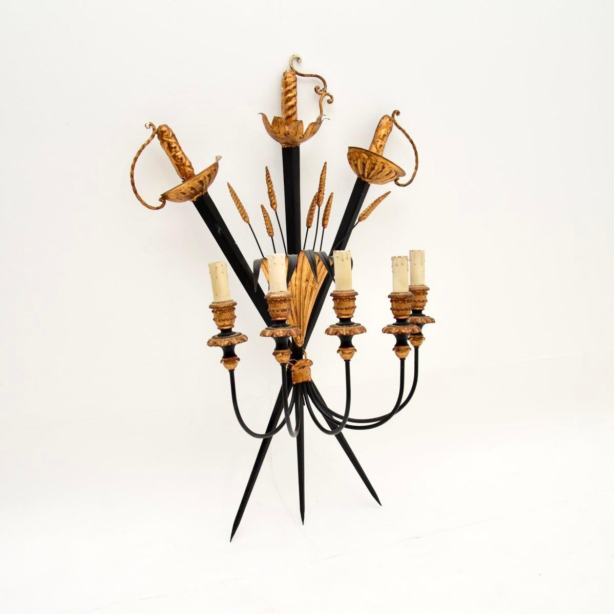 Una grande e imponente lampada ad applique da parete in metallo dorato a forma di foglia di grano e di sciabola. Prodotto in Inghilterra, risale agli anni '1930 circa.

Il design è splendido e la qualità è eccezionale. Le tre spade si incrociano per