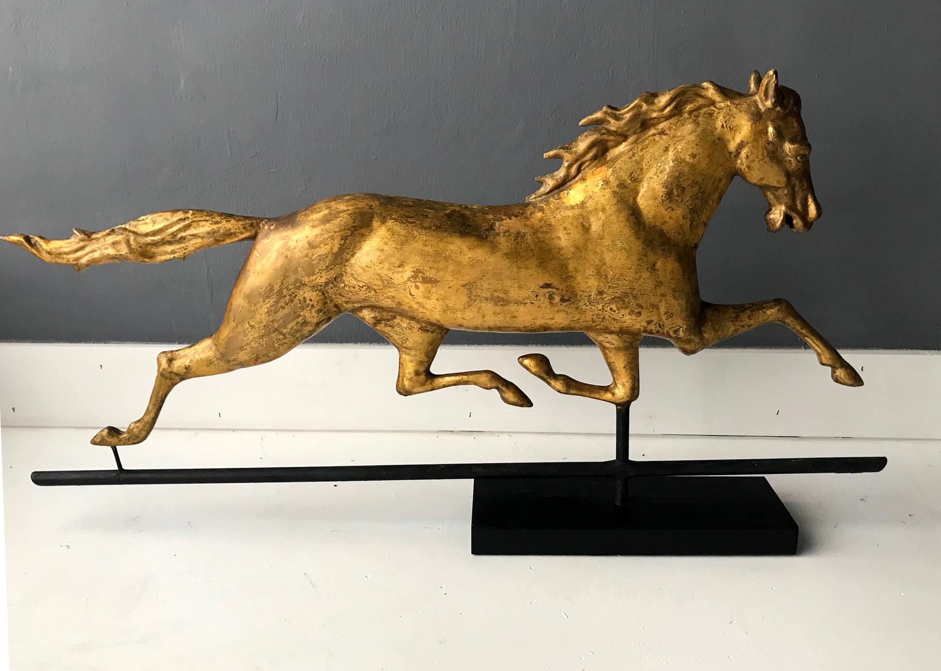 A spectacular full body running horse weather vane attributed to J.W. Fiske, on the original mount and displayed on a simple black wood base. The well sculpted horse is in a prancing stance with a lively rendering. It was removed from the Carriage