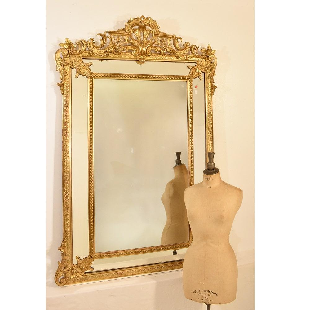 The antique rectangular gilt wall mirror, old mirror with flowers and the Lyres on the corners proposed here
is an elegant mirror and has a Golden Frame in pure Gold Leaf and it carries side mirrors with rich decorations on the sides.

This