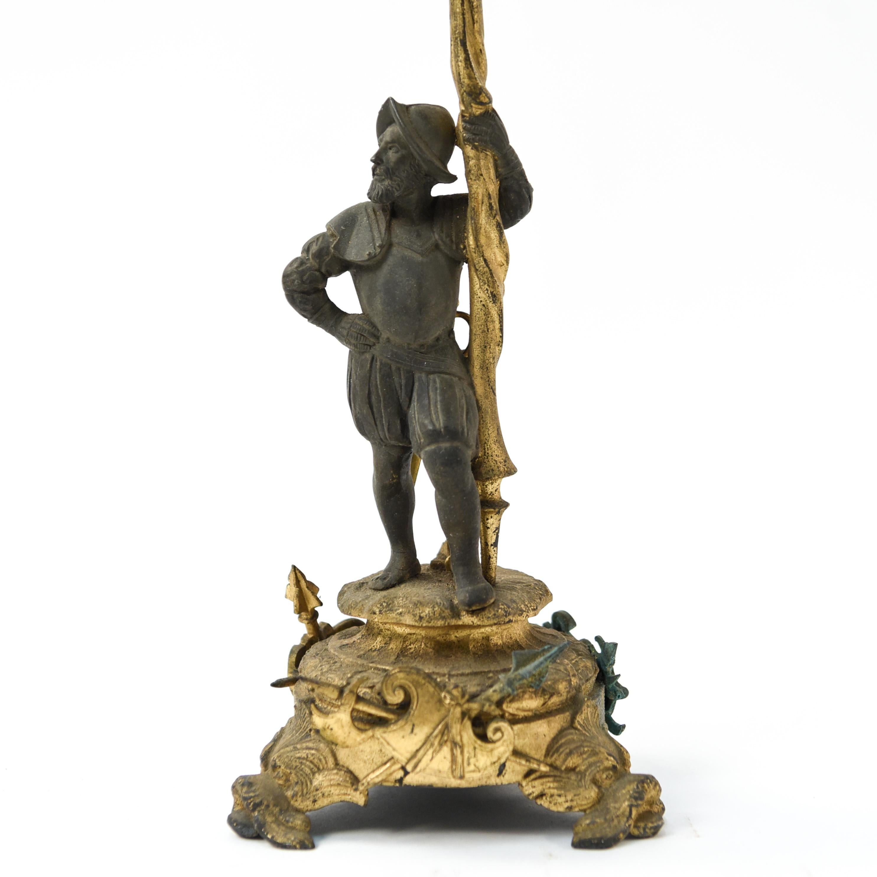 This antique four-arm white metal candelabra of interesting form depicts a man with a sword.