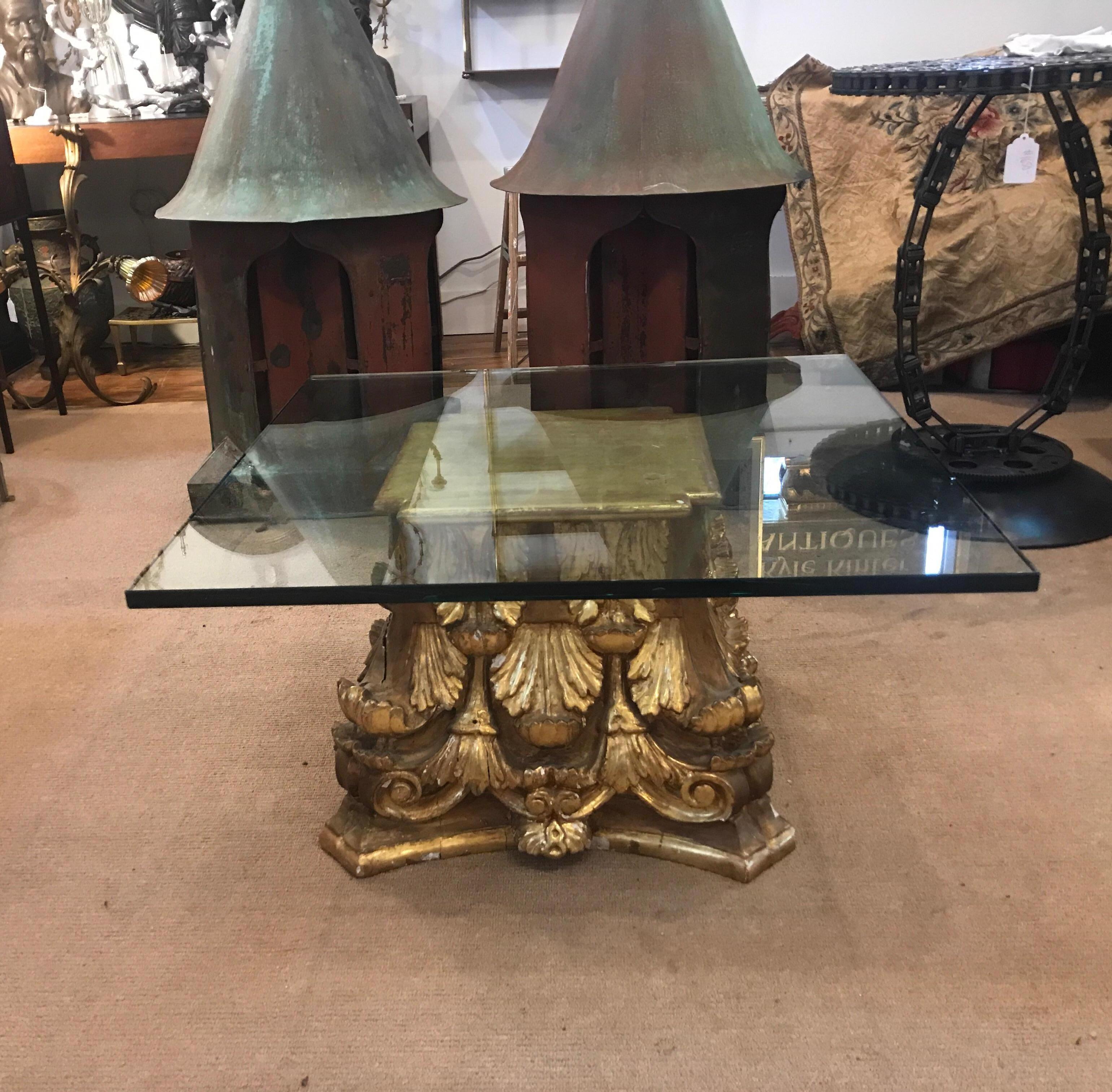 Very sophisticated hand caved giltwood and gesso antique column capital now as a coffee table. The base in a hand gilt mid to late 19th century architectural column with a hand gilt top added later and a very thick 32 inch square glass top. The