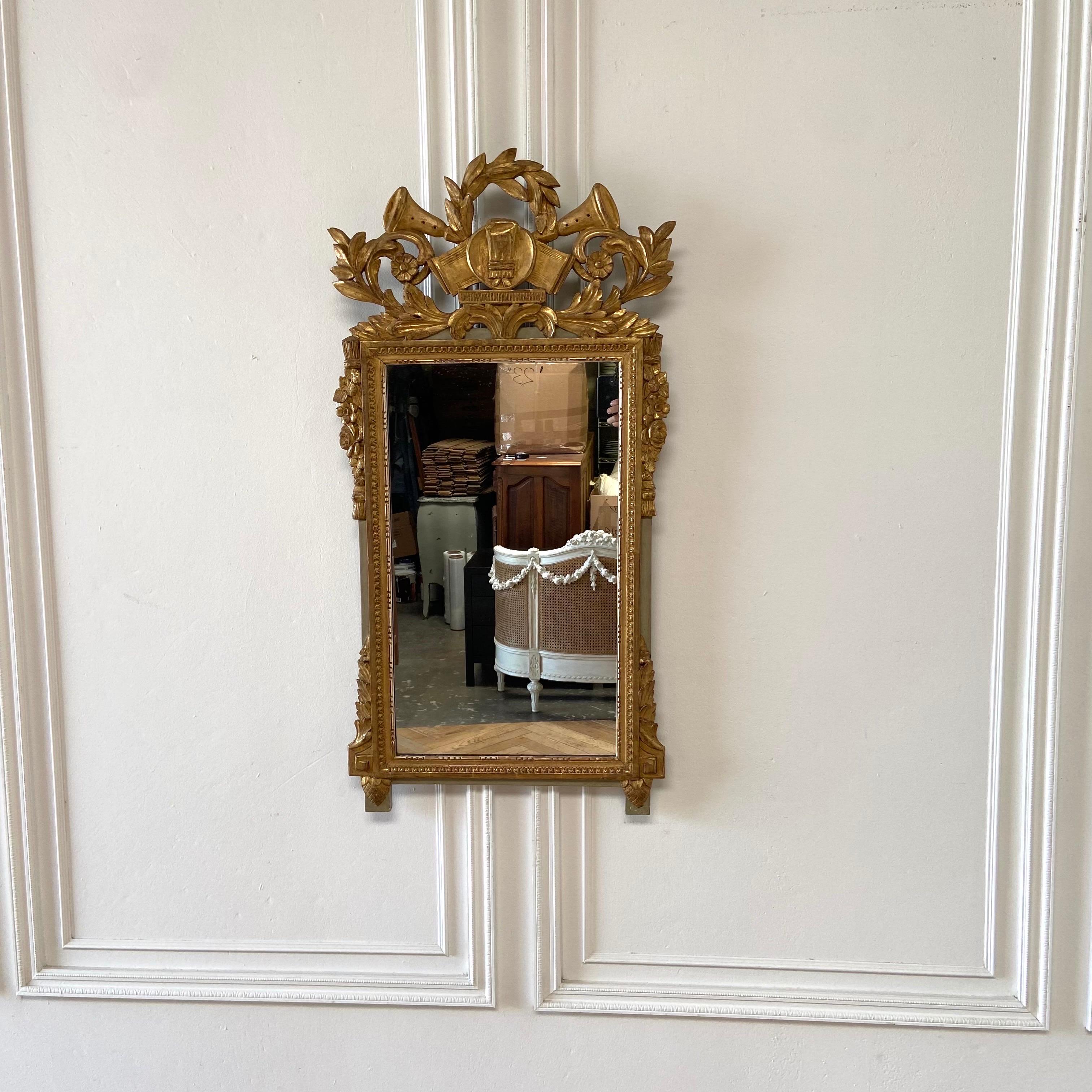 Neoclassical gilt wall mirror 
Size: 23” W x 45-1/2” H
Condition: minor repairs, frame and carvings are solid and ready to hang. 
Mirror has soon minor imperfections. Not original to the frame. 
 