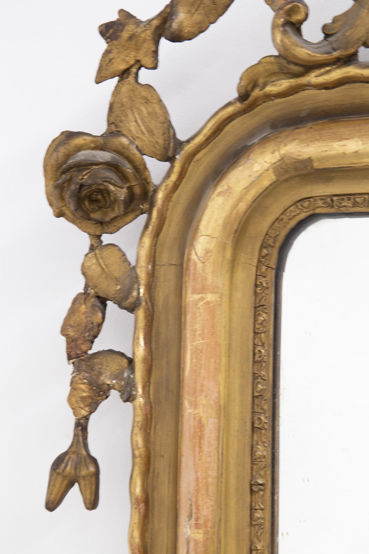 Wonderful gilt wood wall mirror designed in the 1800 1900, fine French manufacture.
The mirror is made entirely of gilt wood, with a rectangular shape beveled at the top corners. The uniqueness of this mirror lies in its decorations: in the two