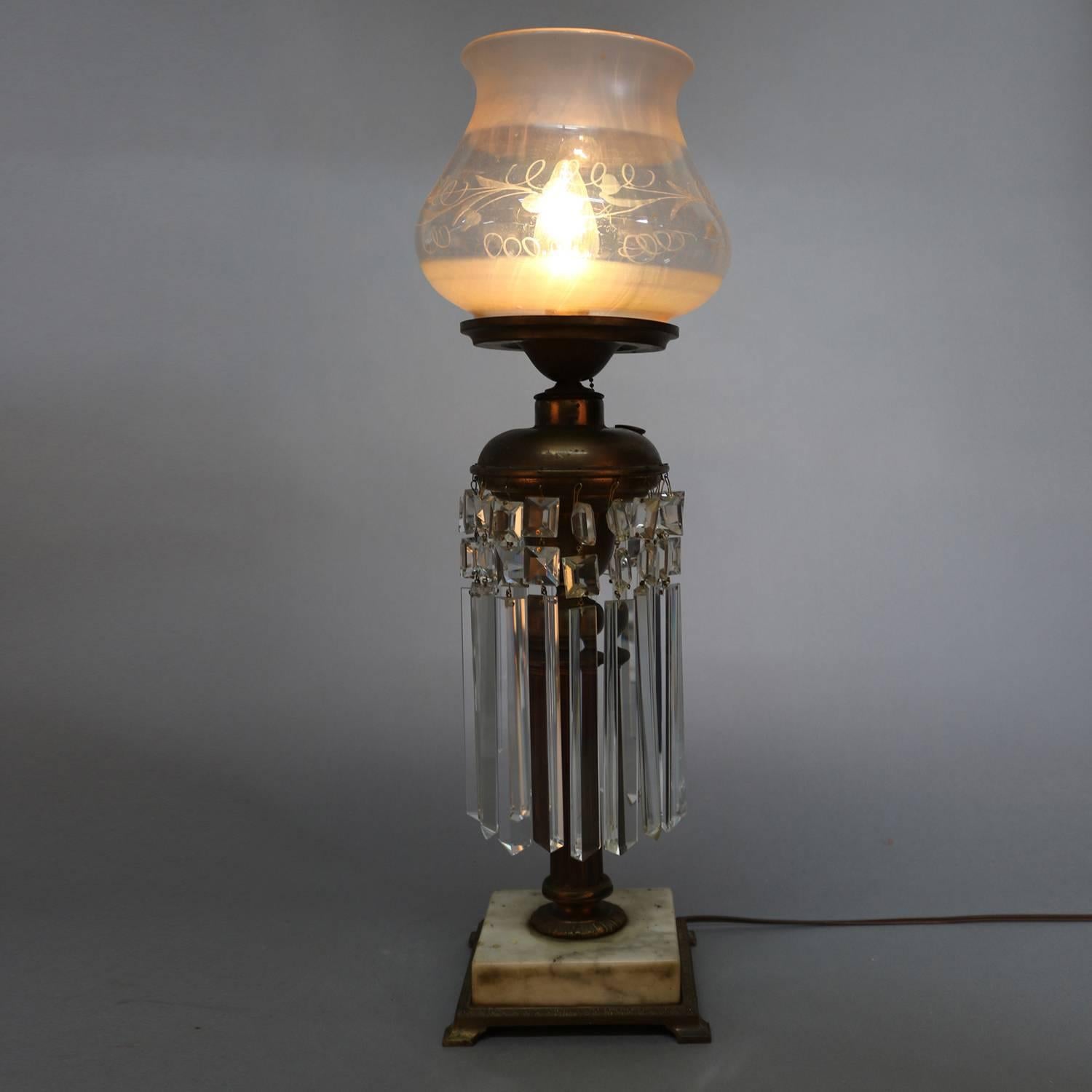 Antique gilt bronze electrified solar lamp features reeded pedestal supporting font laden with hanging cut crystal prisms, marble base with footed gilt base with egg and dart trimming, etched glass glove with floral decoration, newly re-wired,