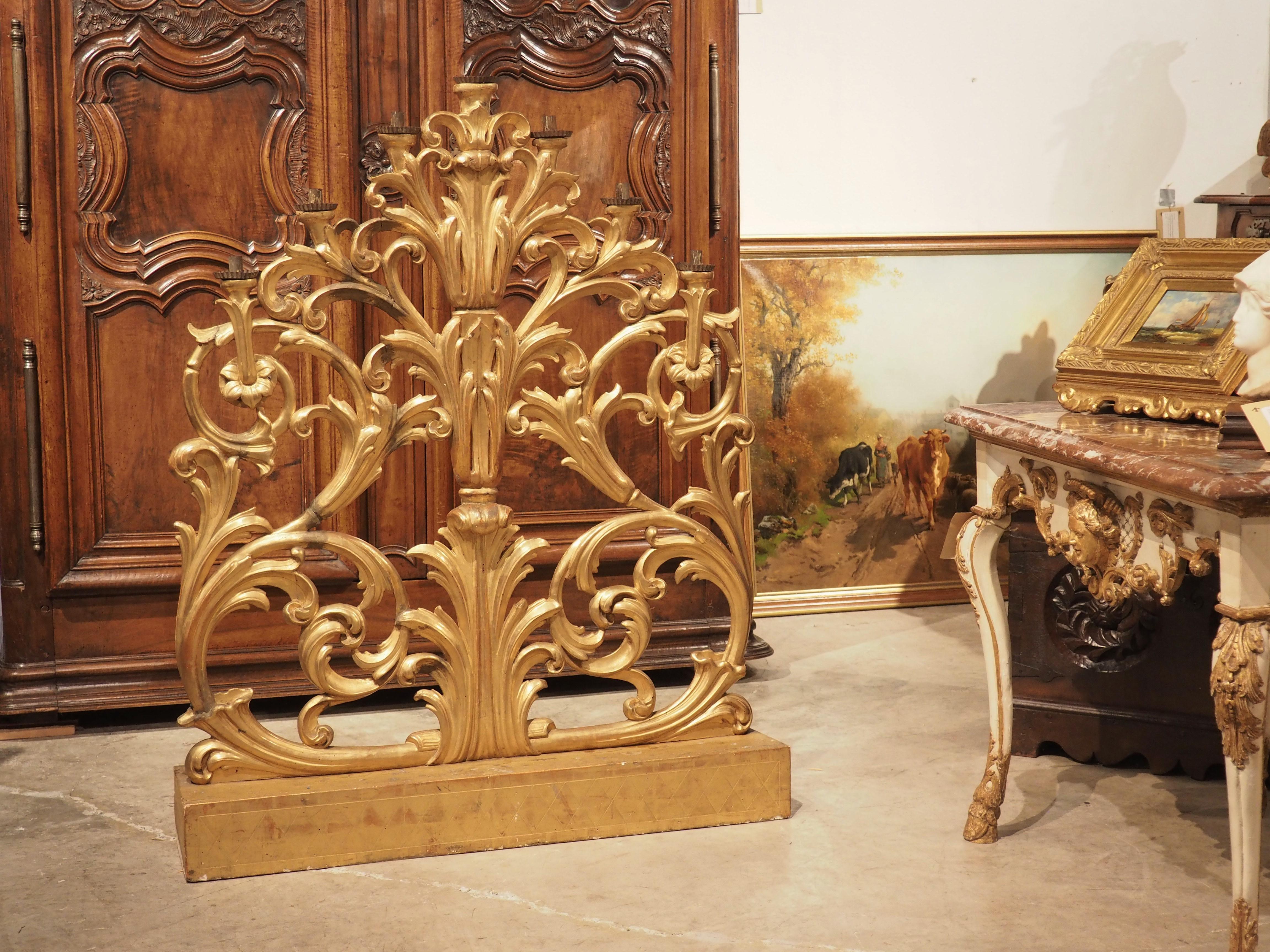 Hand-carved in Tuscany, Italy, circa 1800, this gold leaf altar candelabra has a commanding presence. At over four feet tall and three feet wide, the candelabra is full of movement inspired by nature.

A rectilinear base adorned with a shallow,