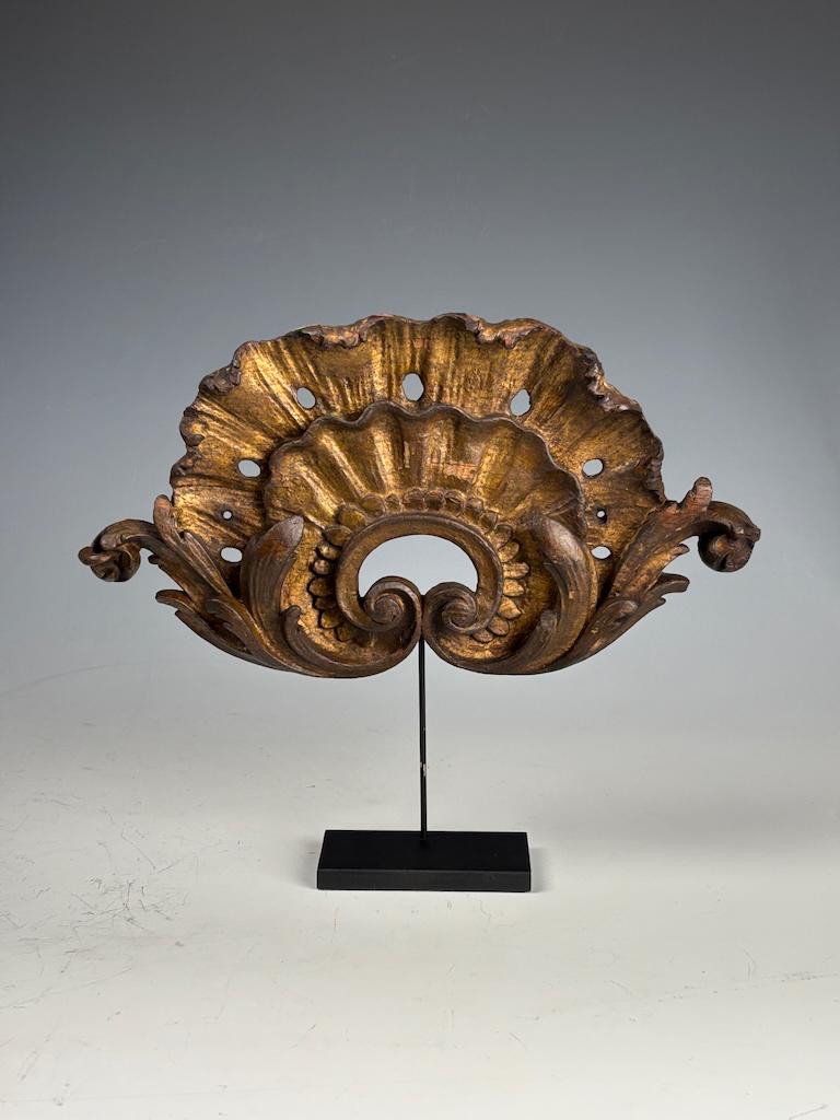 Antique Giltwood Carved Pediment on Stand – Late 18th / Early 19th Century

A stunning and finely carved giltwood pediment, now beautifully mounted on a custom metal stand for display. This elegant decorative piece features a classic scallop shell