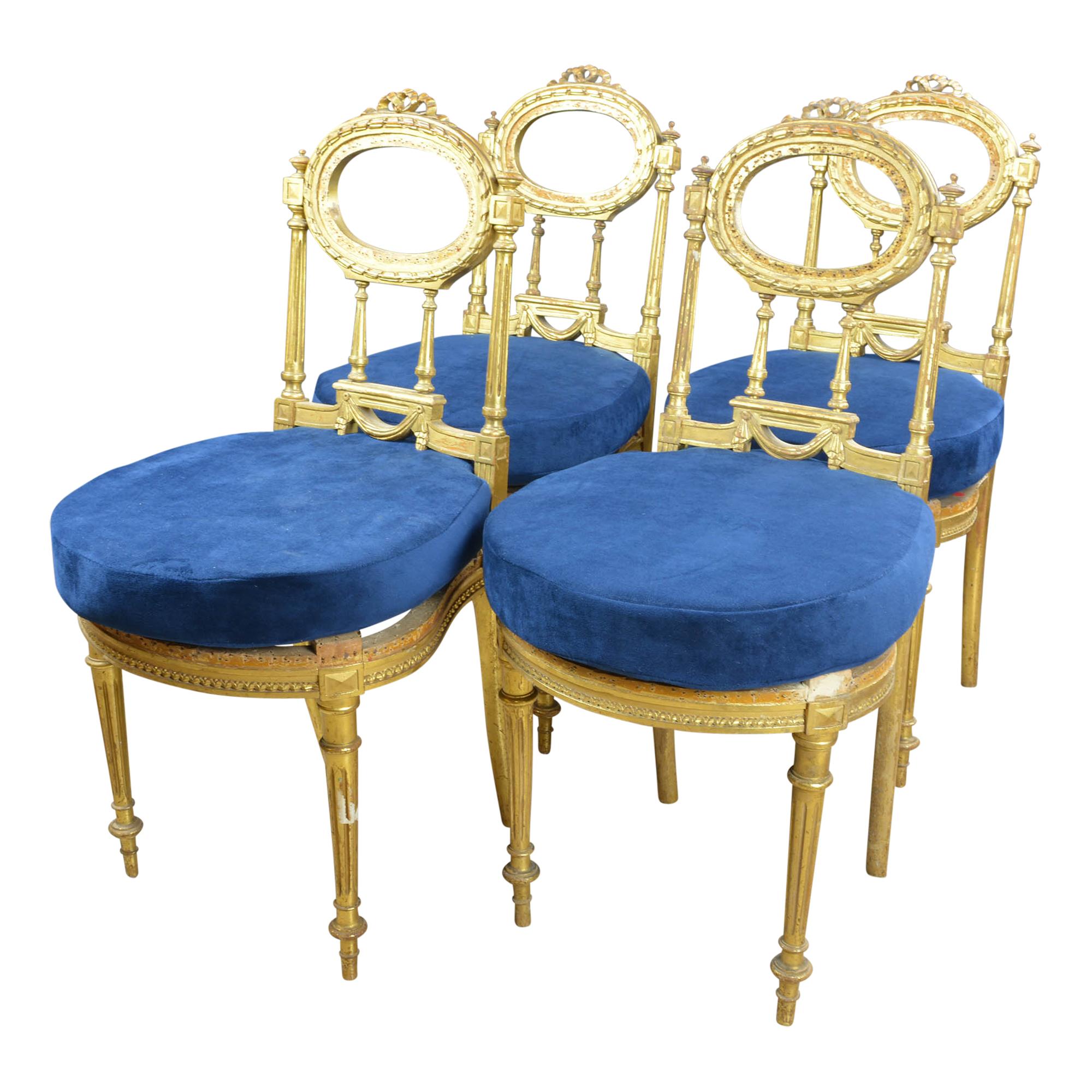 Matching set of four petite giltwood chairs have been paired with deep blue velvet cushions. The chairs have an open back with a spot to have additional cushion added. We have opted to leave it open as we find this add more interest to the chairs.