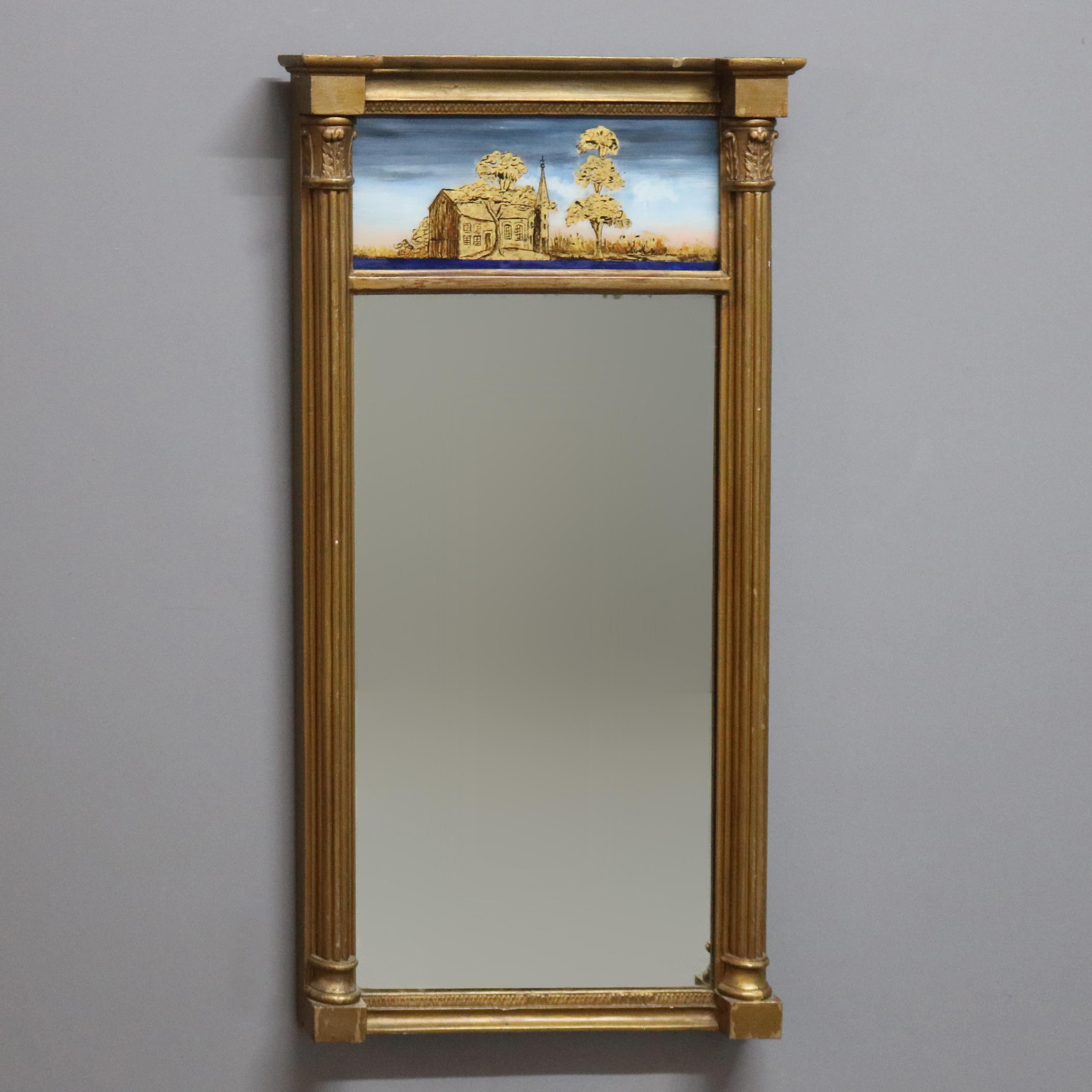 An antique wall mirror offers giltwood construction with reverse painted upper panel having countryside scene with church, c1890

Measures - 36