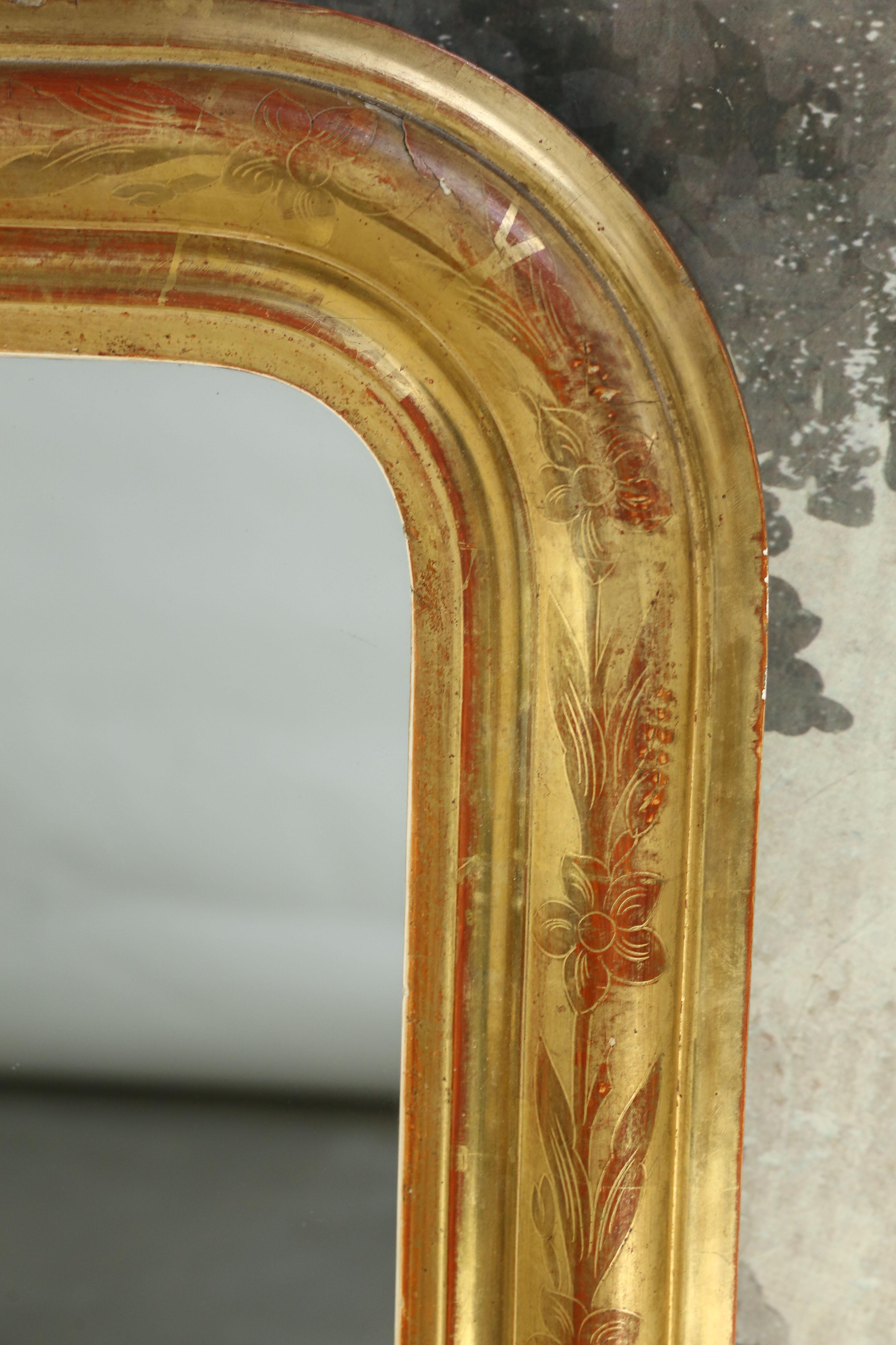 Beautiful French Louis Philippe mirror with intricate incised floral motifs. The glass mirror was probably added at a later date. Red and yellow bole has been used on this wonderful Louis Philippe giltwood mirror from the 19th century.