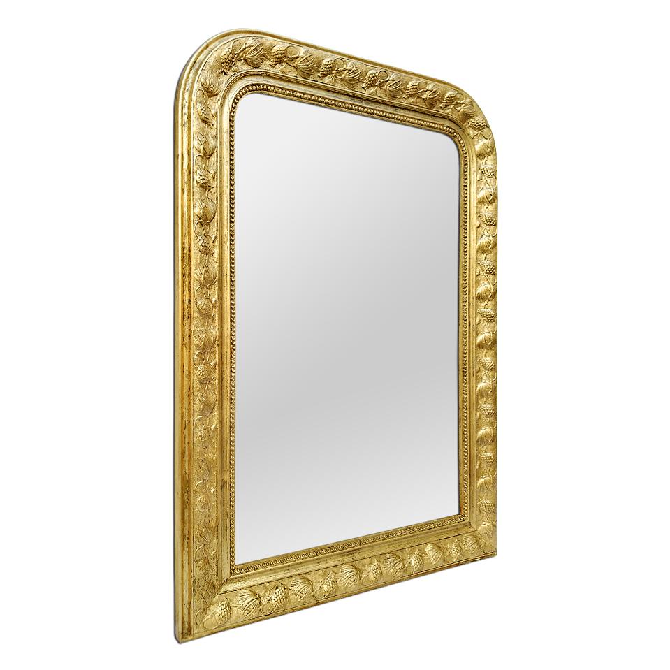 Antique giltwood Louis Philippe style mirror decorated with pearls and exotic stylized flowers, circa 1930. Re-gilding to the leaf patinated. Modern glass mirror. Antique frame measures: Width 11 cm / 4.33 in.