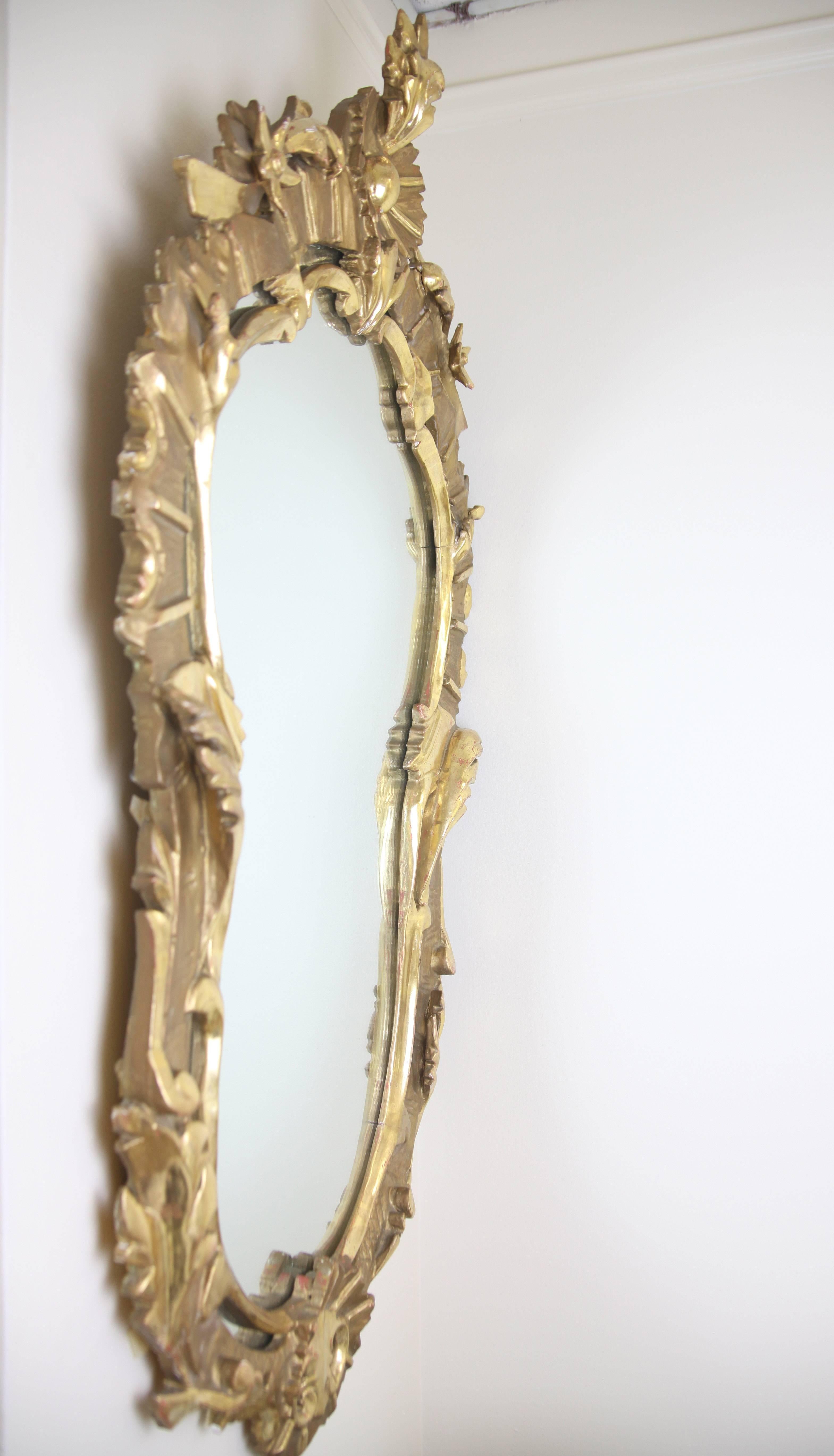 This very unusual mirror features beautiful water gilding as well as the more traditional giltwood finish. The origin of this mirror is unknown but is likely French or Italian.