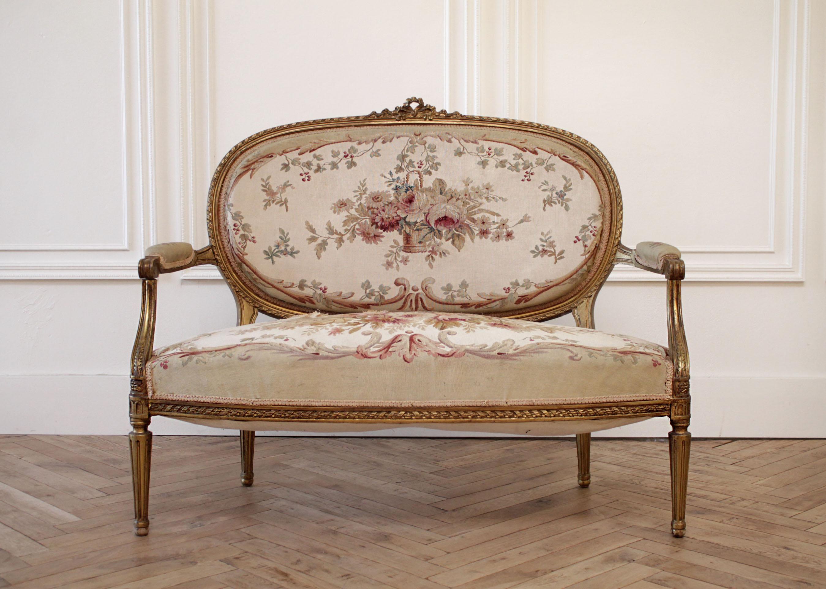 Early 20th century giltwood Ribbon carved settee with original needlepoint
Original gilt wood has great patina, upholstered in original needlepoint tapestry. The upholstery has some wear, the seat has a small hole. See photos.
We can assist with