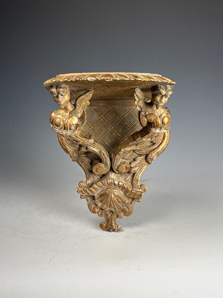 Antico supporto da parete in legno dorato con grifoni - Rinascimento

Superbo esempio di artigianato rinascimentale del XIX secolo, questa staffa da parete in legno dorato finemente intagliato presenta una coppia di grifoni mitologici alati,