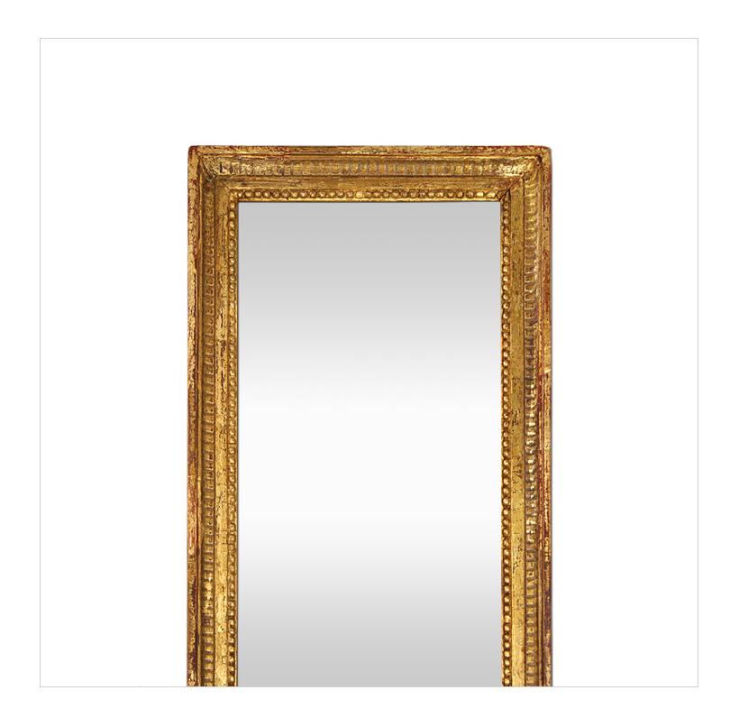 Large antique giltwood mirror, Louis XVI style, French mirror circa 1900. Antique giltwood frame decorated with fluting and pearls around the edge of the glass mirror. Re-gilding to the patinated leaf. Antique wood back. Antique frame width: 4 cm.