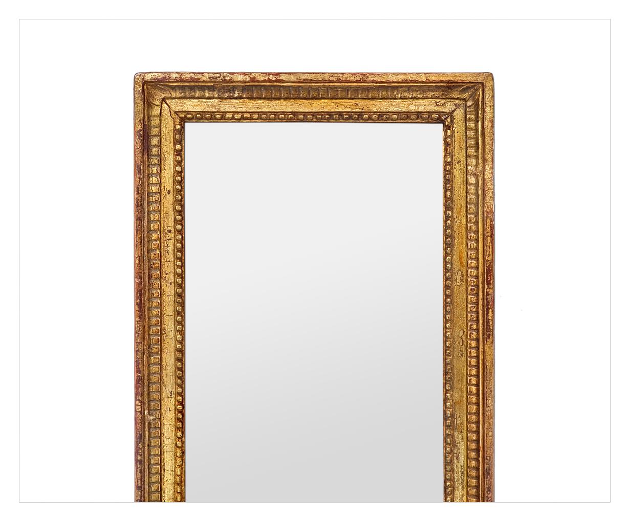Gran espejo antiguo de madera dorada, estilo Luis XVI, espejo francés de hacia 1900. Marco antiguo de madera dorada decorado con estrías y perlas alrededor del borde del espejo de cristal. Anchura del marco antiguo: 4 cm. Volver a dorar la hoja