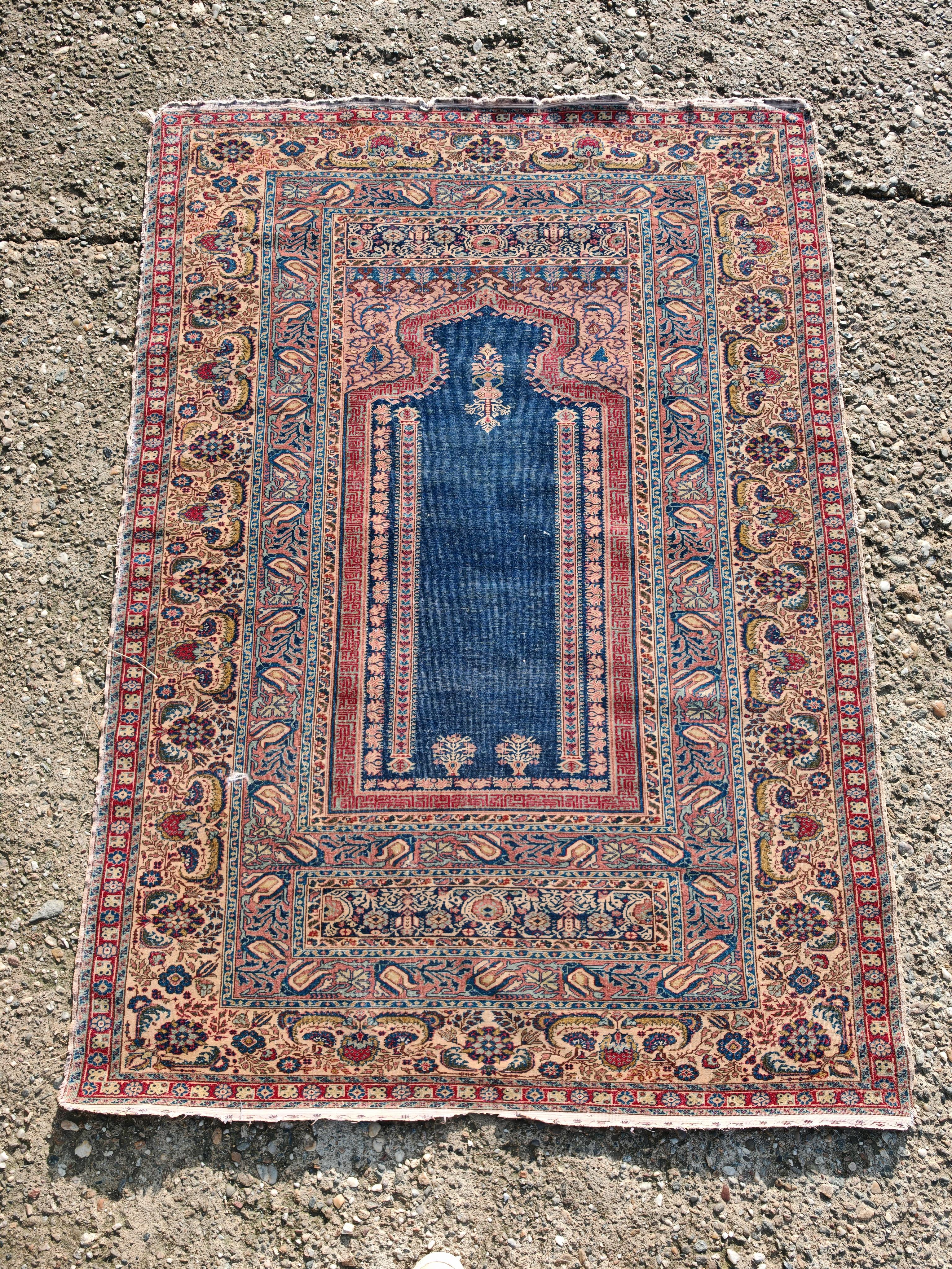 En este anuncio encontrarás una impresionante alfombra de oración turca antigua Ghiordes, también conocida como alfombra de oración Gordes. Estas alfombras son originarias de la ciudad de Ghiordes, en el oeste de Turquía, y son conocidas por sus