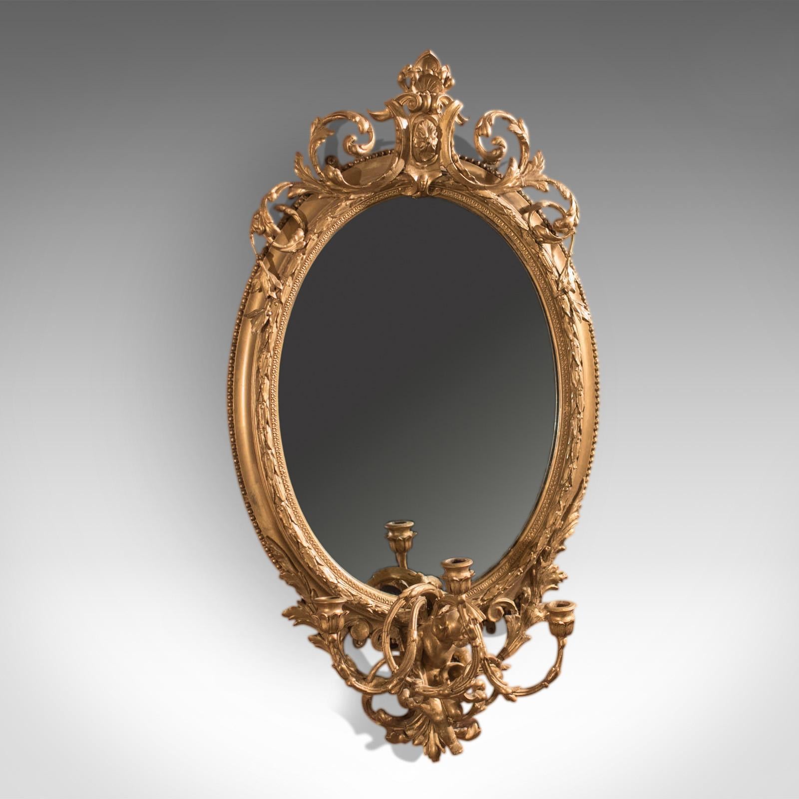 Es handelt sich um einen antiken Girandole-Spiegel aus der Zeit der Wende vom 18. zum 19. Jahrhundert, also um 1800.

Ein großartiges Beispiel, dieser Wandspiegel ist in Vergoldung und Gesso gerahmt, die Form um die spätere Spiegelplatte zeigt