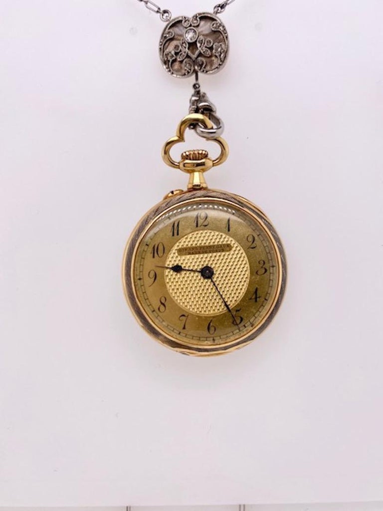 Luminous watch pendant.  Made and signed by GIRARD-PERREGAUX.  Solid gauge 18K yellow gold.  The front is a glowing gray guilloche enamel.  Set with rose-cut diamonds, in platinum setting,  and with white enamel tracery.  On a gorgeous enamel bail,