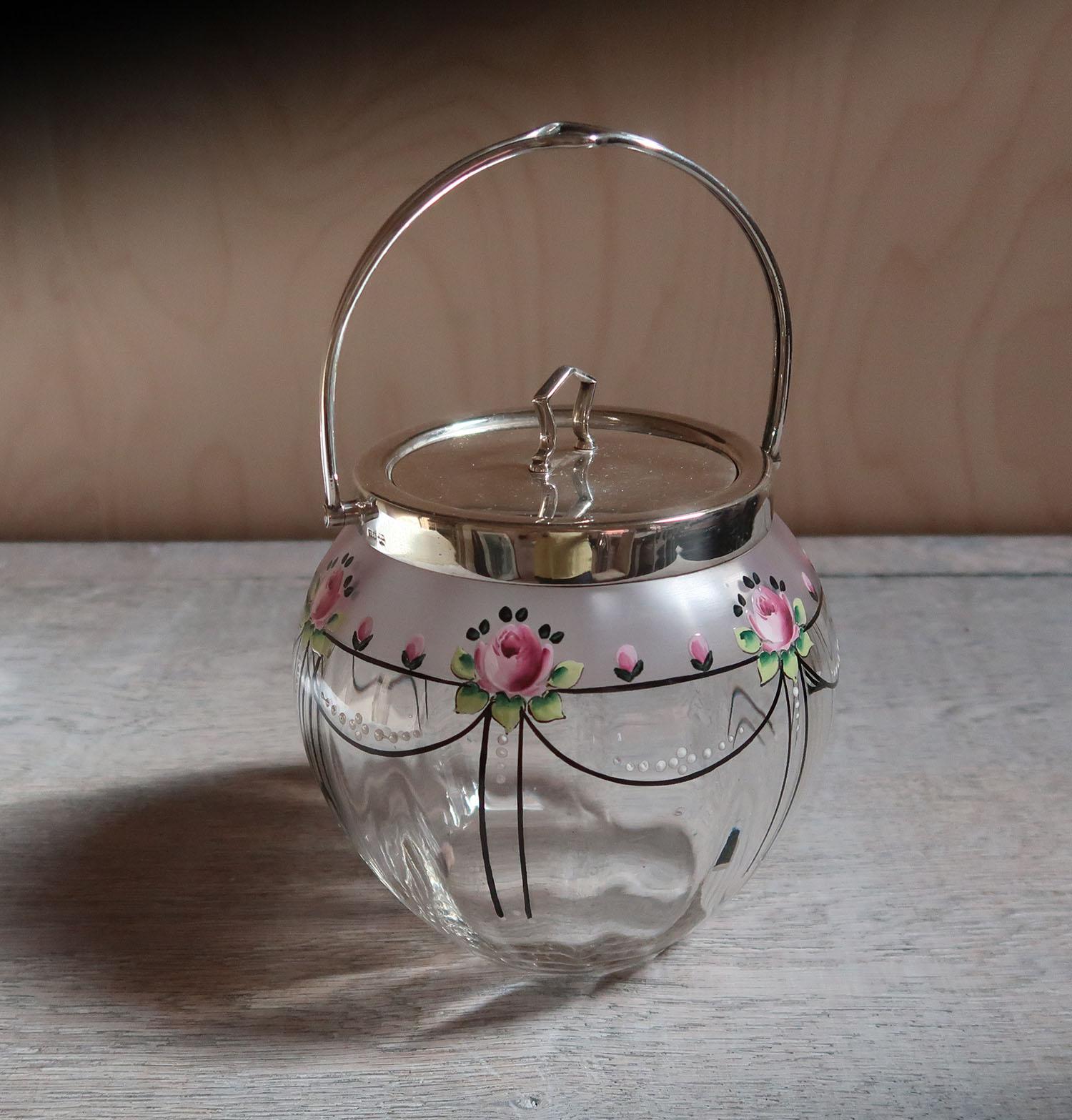 Very pretty glass biscuit barrel or cookie jar

Enamel rose decoration on glass. Silver plated mounts

There is a matching salad bowl available on the site.

The size given is with handle down.











