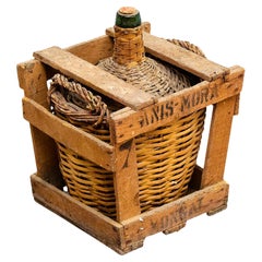 Jarrón antiguo para botellas de vidrio con cesta de mimbre, hacia 1960