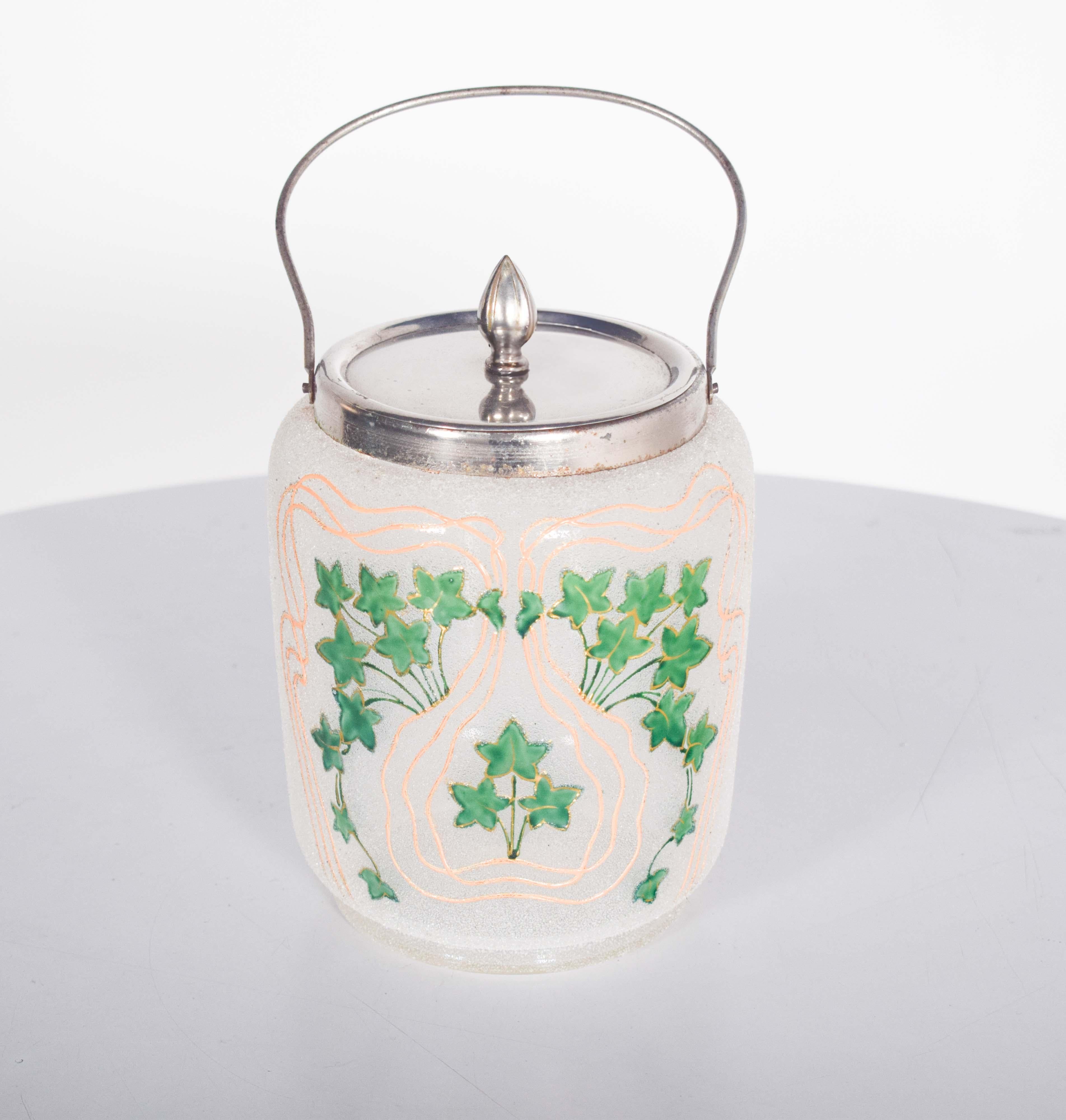 This antique glass cake stand is a charming and functional piece, showcasing elegant craftsmanship. The stand features a beautifully clear glass surface, with a chromed metal handle and lid that add a sleek, vintage touch. The cake stand is adorned