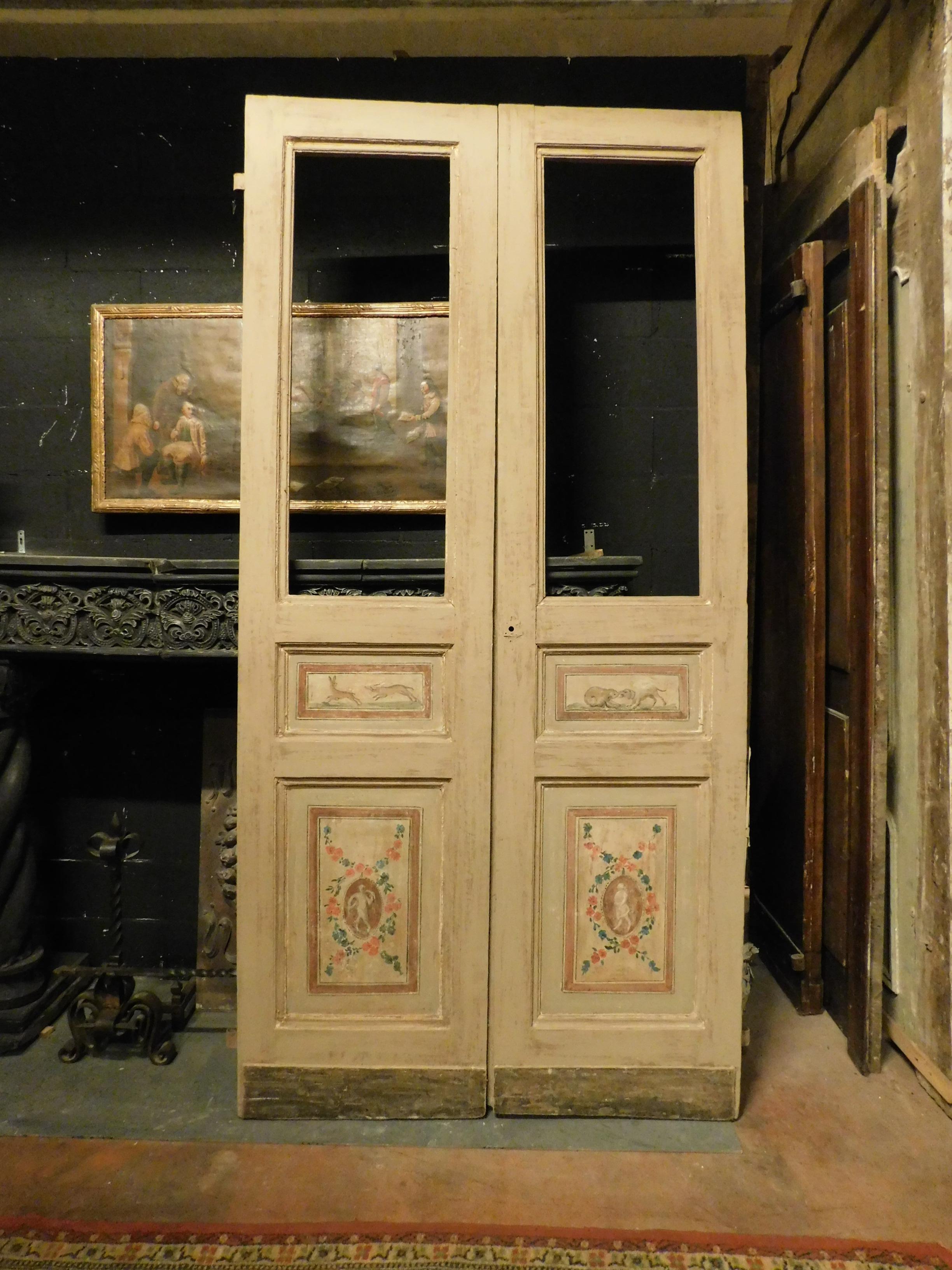 Antique interior door with glass, double-leaf with carved panels and original paintings, painted and finished on both sides, beautiful patina of the time, hand-built in the late 18th century for a home in Italy.
It has original and beautiful