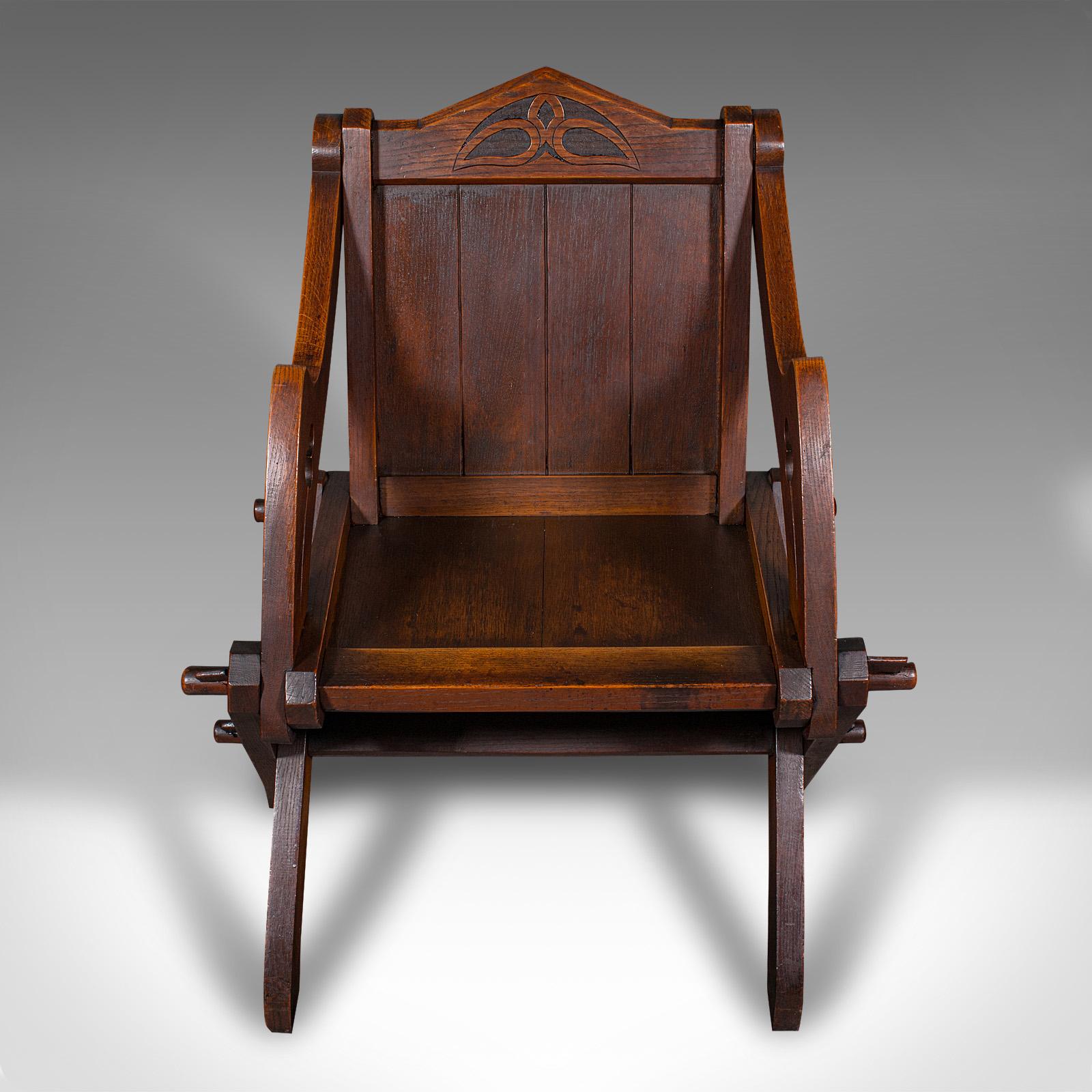 This is an antique Glastonbury chair. An English, oak ecclesiastical armchair with Gothic overtones, dating to the late Victorian period, circa 1880.

Appealing Glastonbury chair with delightful Gothic revival overtones
Displaying a desirable aged