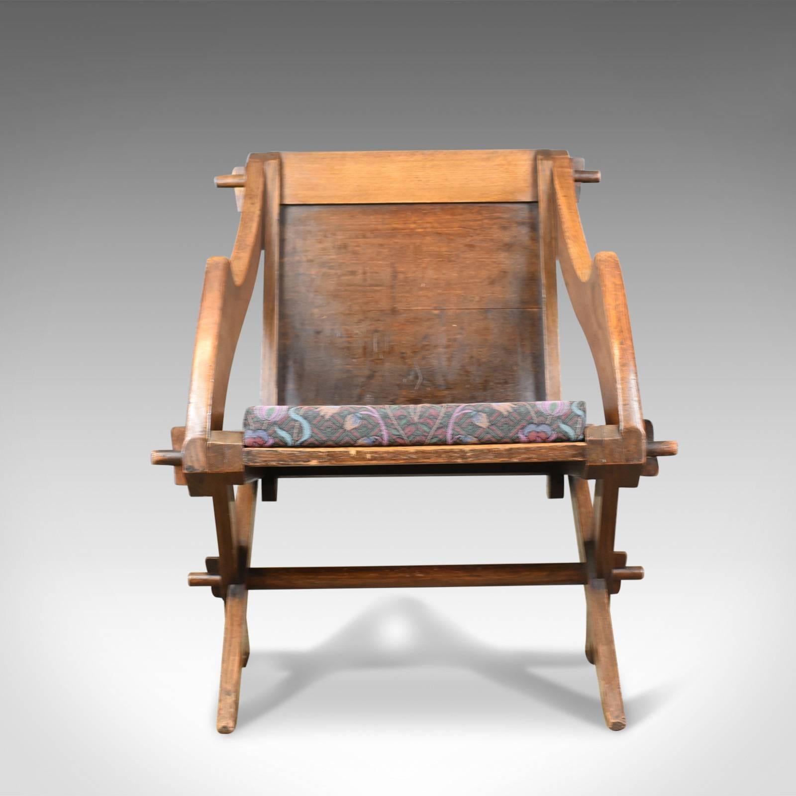 This is an antique Glastonbury chair, English Tudor Revival hall seat dating to the early 20th century, circa 1900.

A fine Glastonbury chair faithful to its origins
Exhibiting ecclesiastical and gothic overtones
Classic tusked joints, the