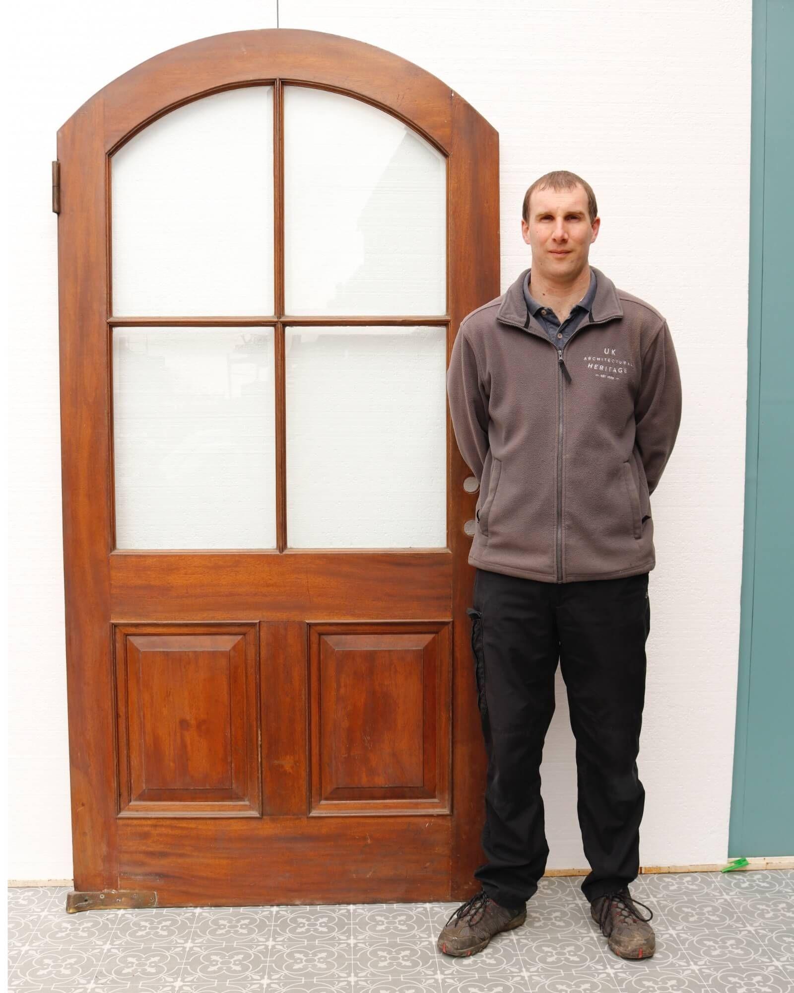 An antique glazed arched interior mahogany door suitable for interior use. This wide scale door was reclaimed from Lincoln Inn Fields, London, from a property near to the Soane’s museum. It incorporates Victorian and Edwardian styles, with two