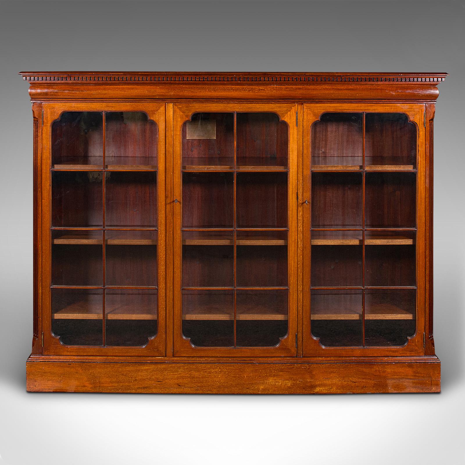 This is an antique glazed bookcase. An English, walnut library cabinet, dating to the Edwardian period, circa 1910.

Established during the Industrial Revolution as the communal church for newly built merchants houses, St. Stephen's of Westbourne
