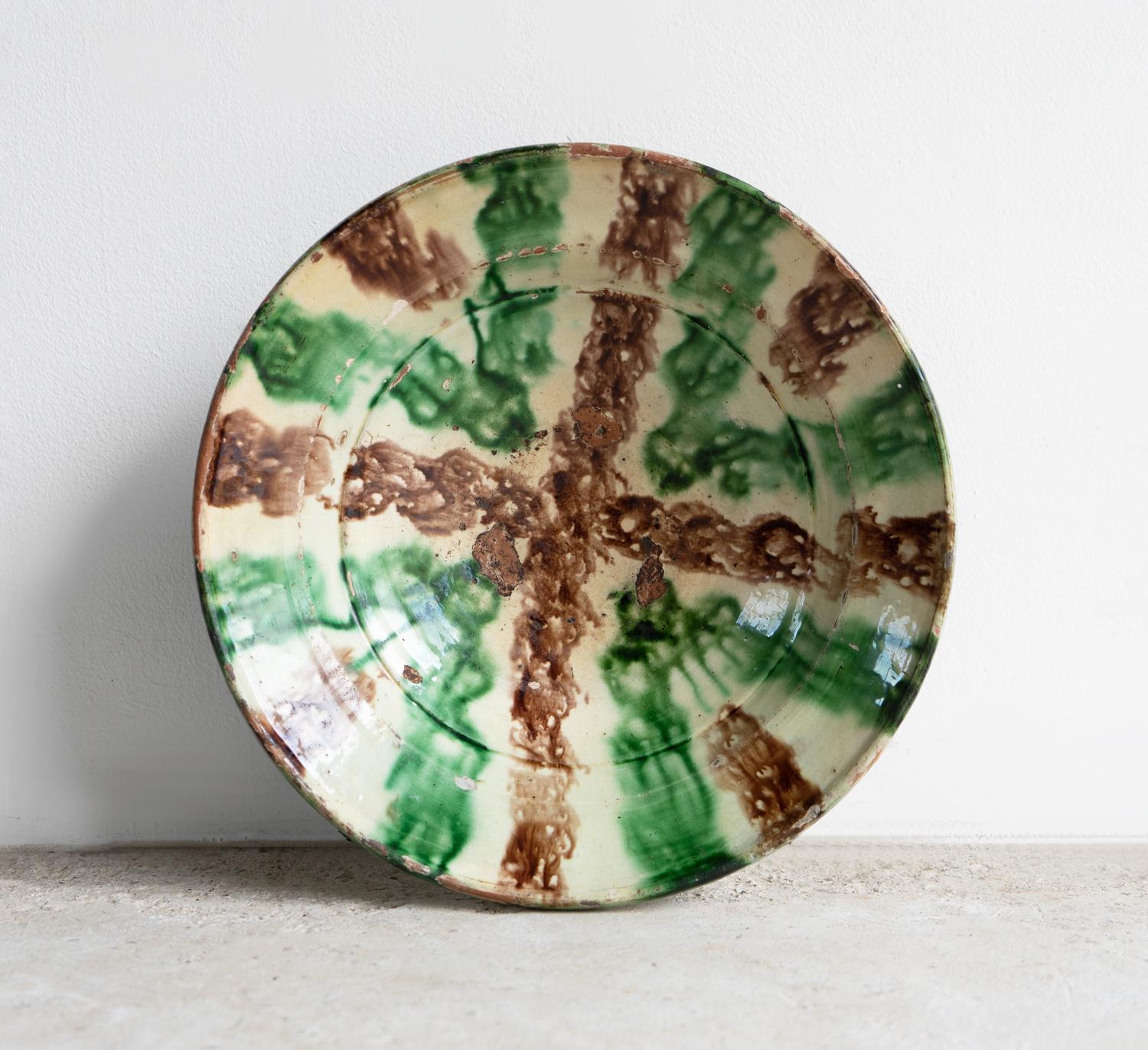 ANTIQUE GLAZED POTTERY BOWL 

A highly decorative bowl with a folky, rustic feel, reddish-brown fired clay decorated with a slipware glaze of a creamy, pale yellow-green ground, featuring sponged decoration in a more vibrant pea-green and brown. 